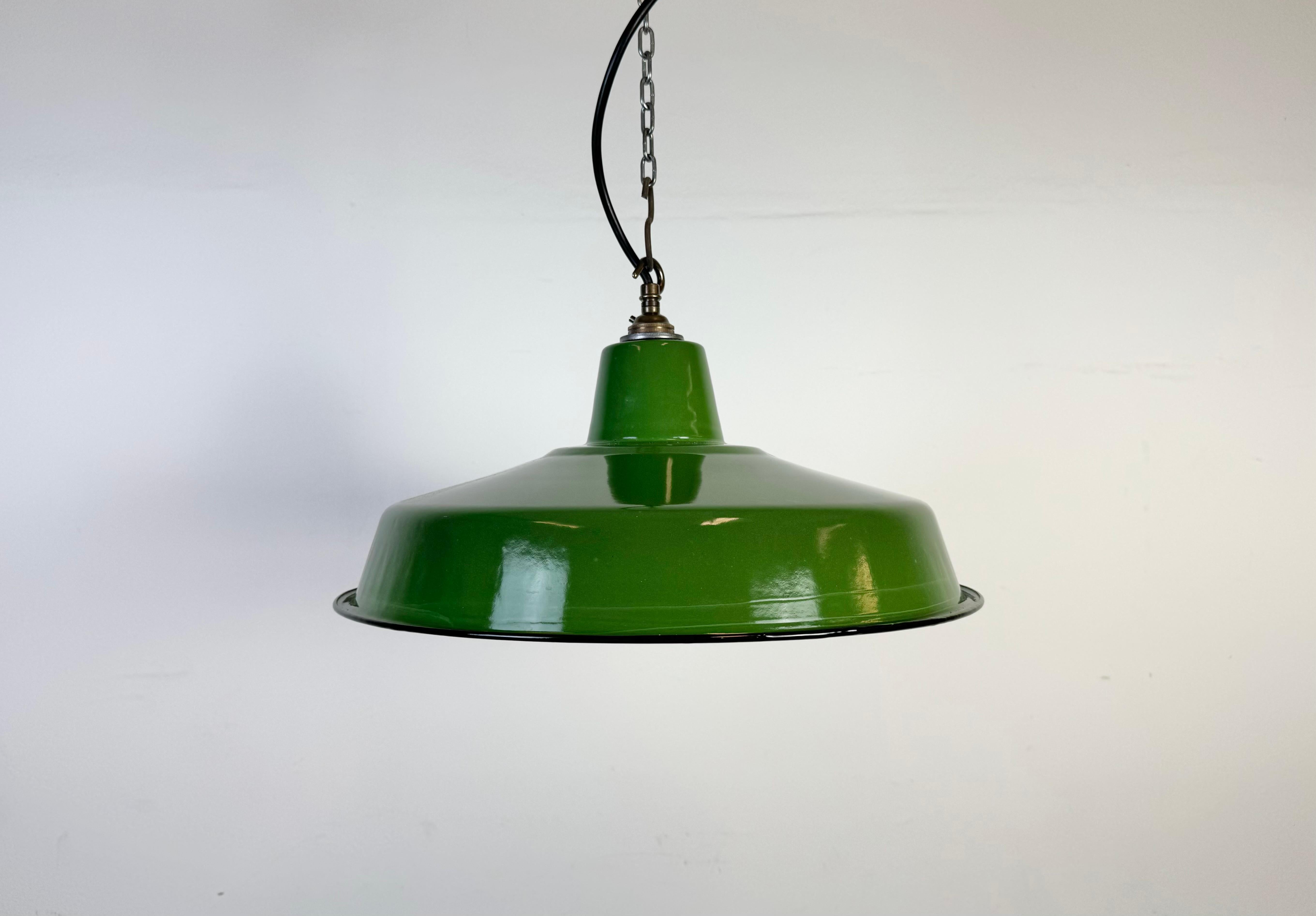 Lampada a sospensione industriale in smalto verde realizzata nel Regno Unito negli anni Sessanta. Smalto bianco all'interno del paralume. Top in ottone. L'attacco richiede lampadine B22. Un nuovo cavo. Il peso della lampada è di 0,9 kg. Il diametro