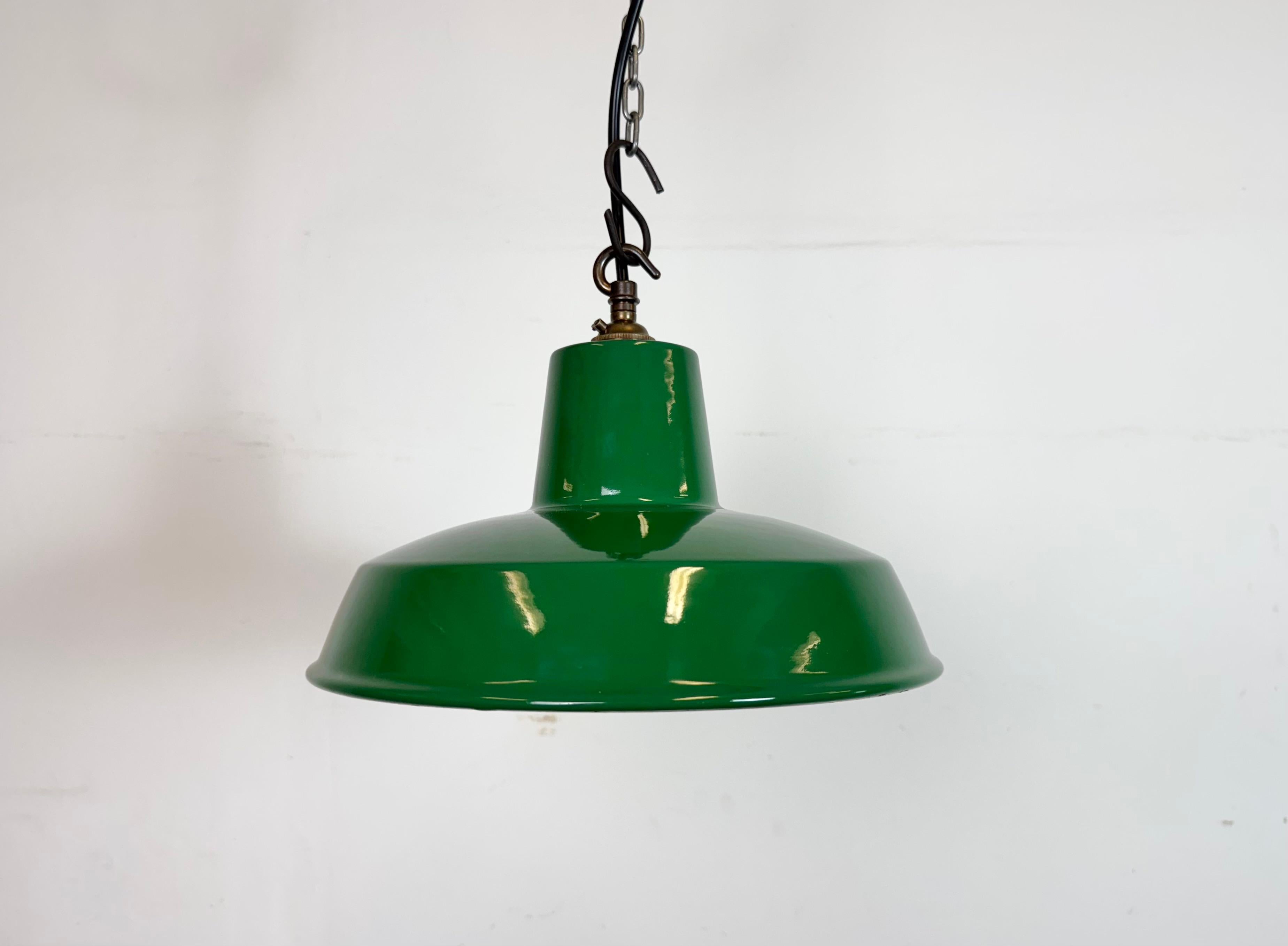 Industrial green enamel factory pendant light made in United Kingdom during the 1960s. White enamel inside the shade. Brass top. The socket requires B22 light bulbs. New wire. The weight of the lamp is 0,8 kg.The diameter of the shade is 28 cm.
