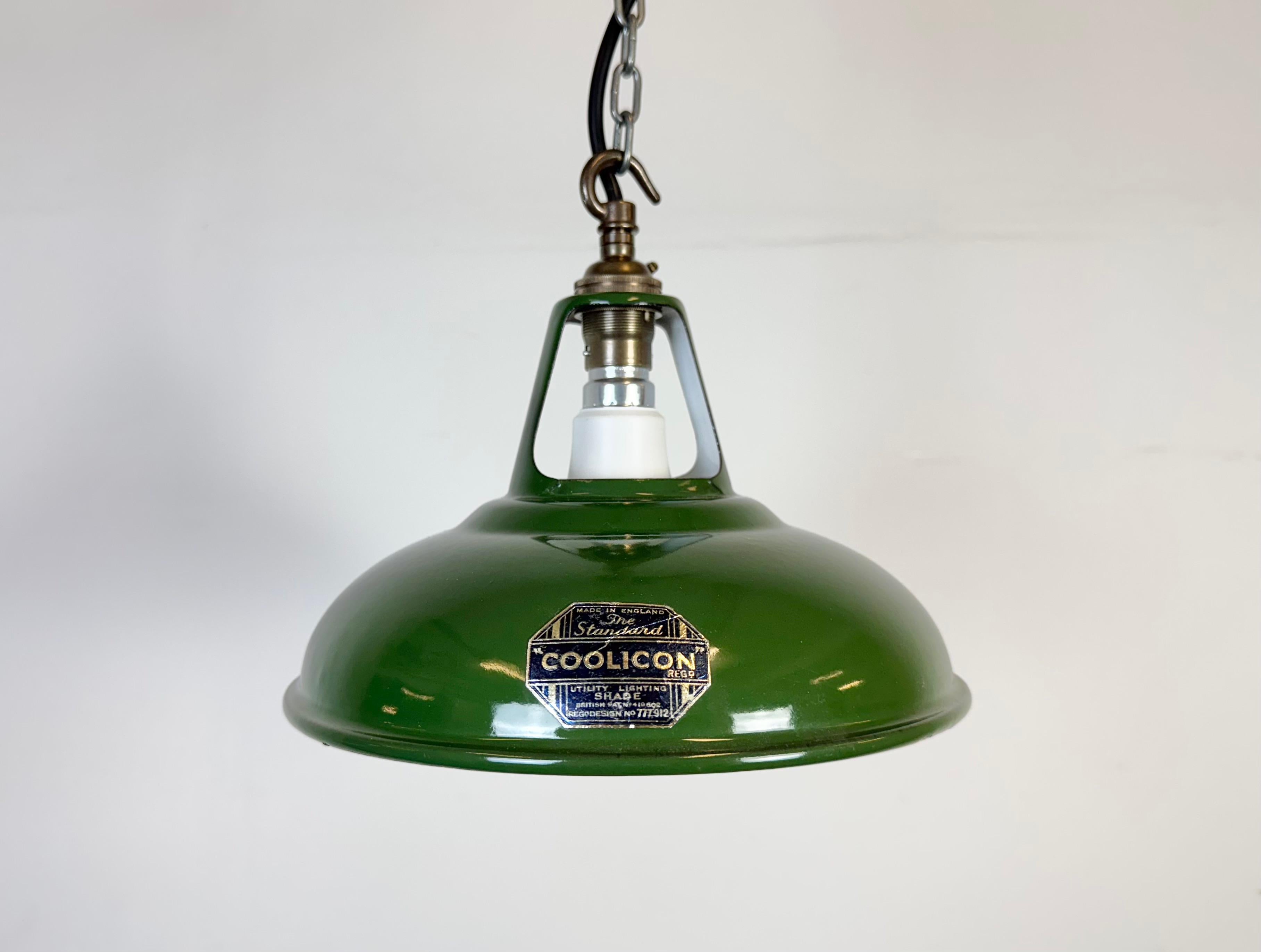 Lampada a sospensione industriale in smalto verde realizzata da Coolicon nel Regno Unito negli anni Cinquanta. Smalto bianco all'interno del paralume. Top in ottone. La presa richiede  Lampadine B22. Un nuovo cavo. Il peso della lampada è di 0,4 kg.