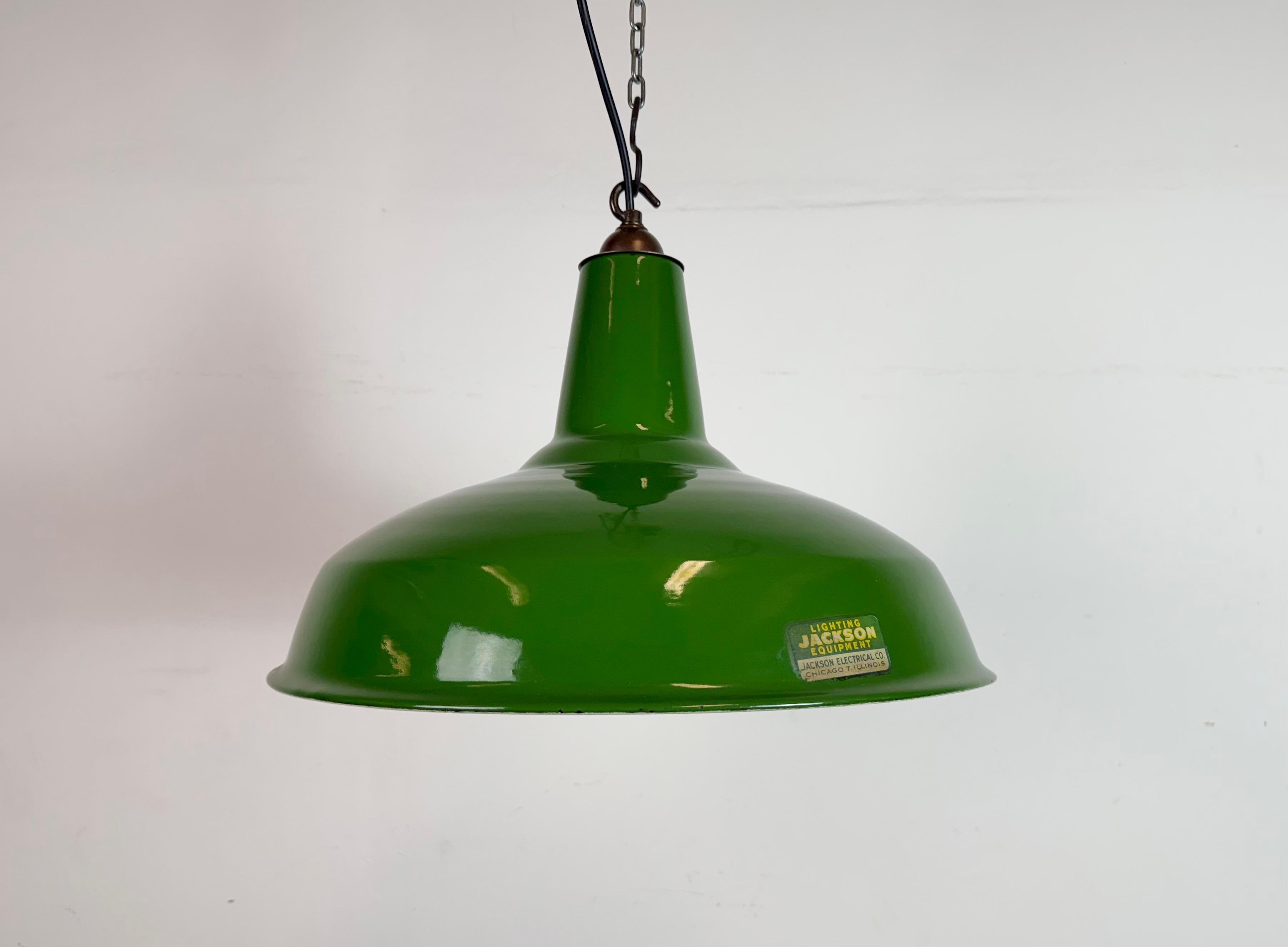 Lampada a sospensione industriale in smalto verde realizzata da Jackson Electric Co. Chicago, Illinois, Stati Uniti, negli anni '60. Smalto bianco all'interno del paralume. Top in ottone. L'attacco richiede lampadine standard E27/E26. Un nuovo cavo.
