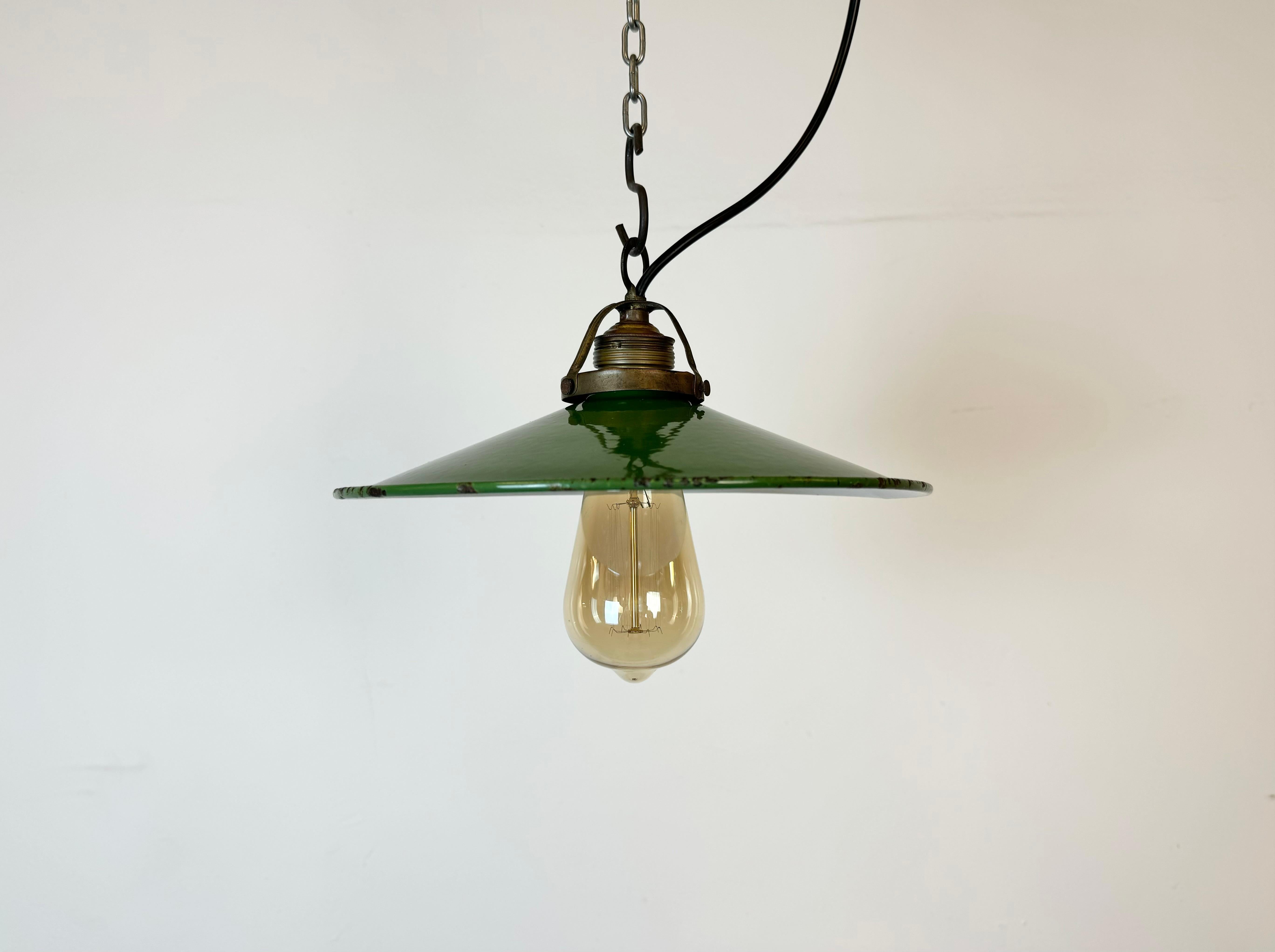 Vintage industrial enamel pendant lamp from the 1930s. It features a green enamel shade with white enamel interior and a brass top. Original porcelain socket requires standard E 27/ E 26 light bulbs. New wire. The weight of the lamp is 0,4 kg. The