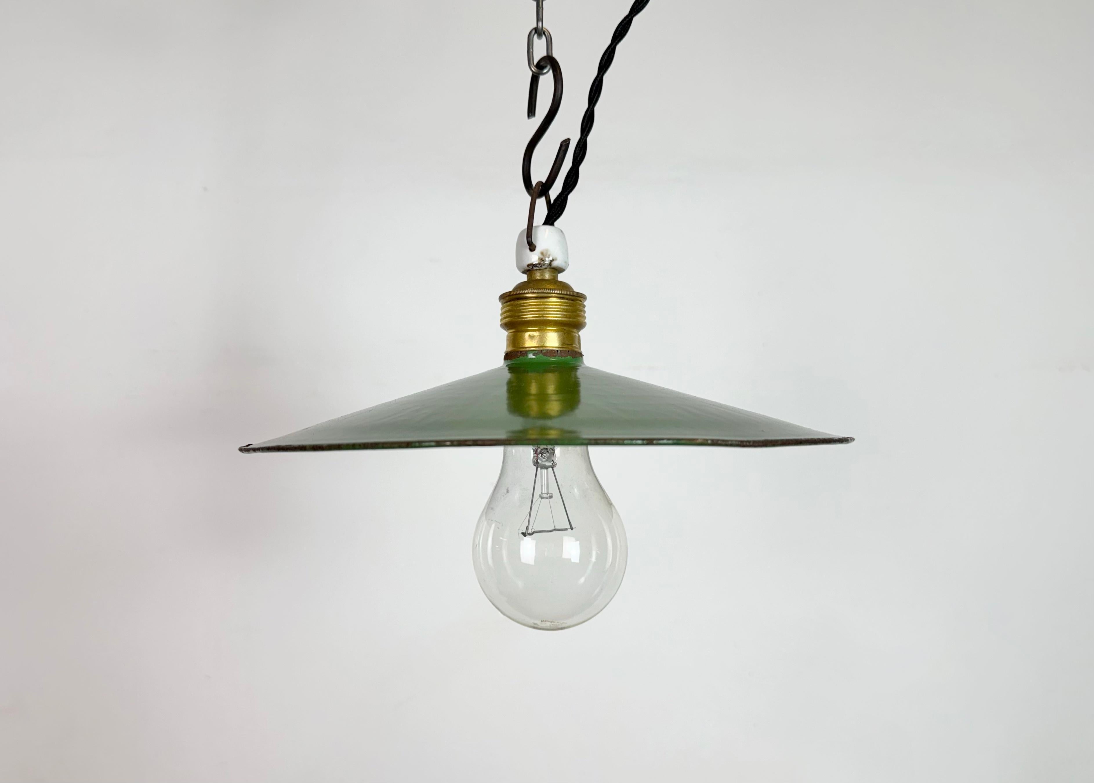 Vintage industrial enamel pendant lamp from the 1930s. It features a green enamel shade with white enamel interior and a brass socket with porcelain top.The socket requires standard E27/ E26 light bulbs. New wire. The weight of the lamp is 0,25kg.