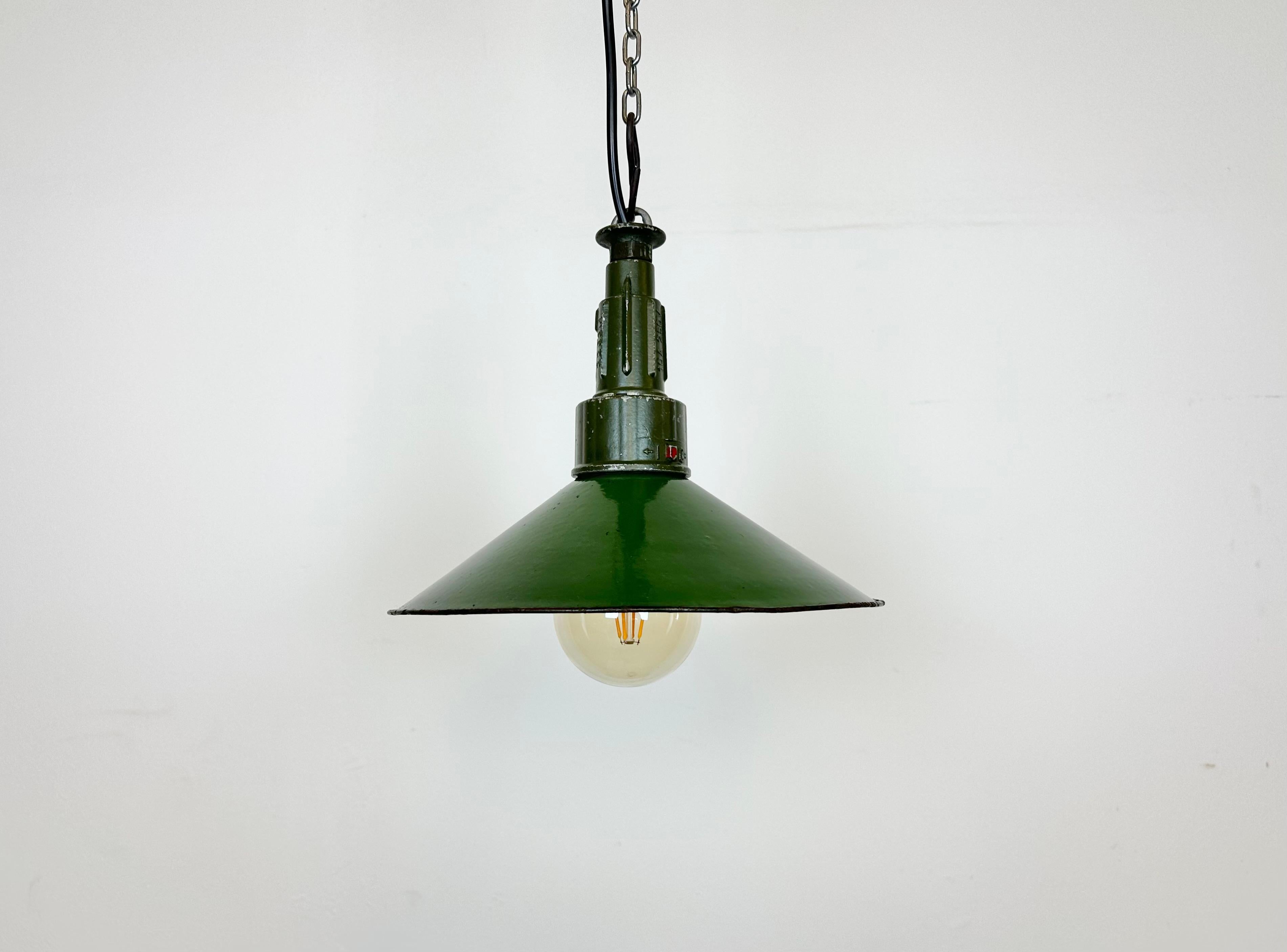 Industrial green enamel pendant light made in Poland during the 1960s. White enamel inside the shade. Green cast aluminium top. The socket requires standard E 27/ E26 light bulbs. New wire. The diameter of the shade is 26cm. The weight of the lamp