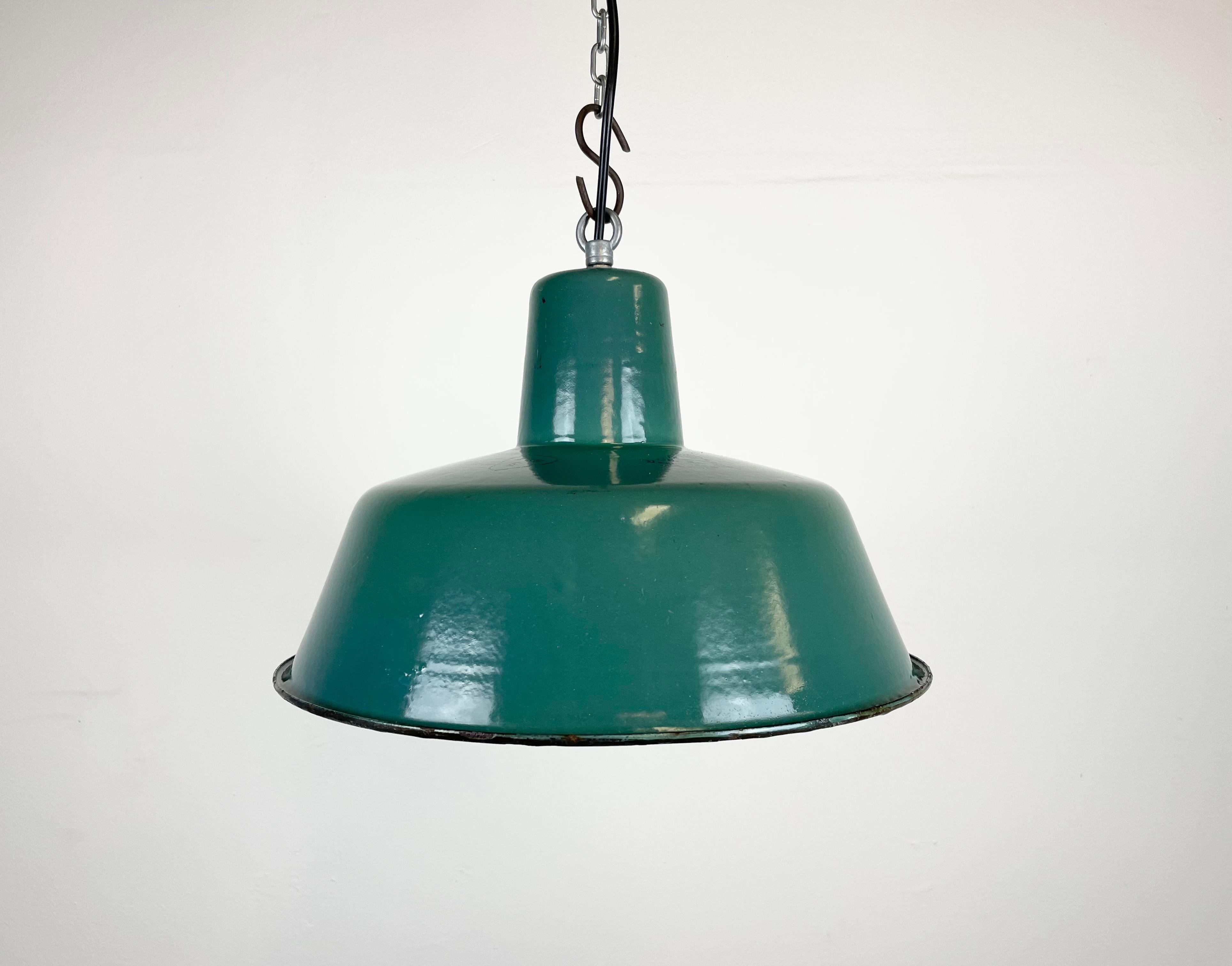 Lampada a sospensione industriale in smalto verde realizzata da KWE in Polonia negli anni '60. Smalto bianco all'interno del paralume. Top in ferro. L'attacco in porcellana richiede lampadine E 27. Un nuovo cavo. Completamente funzionante. Il peso