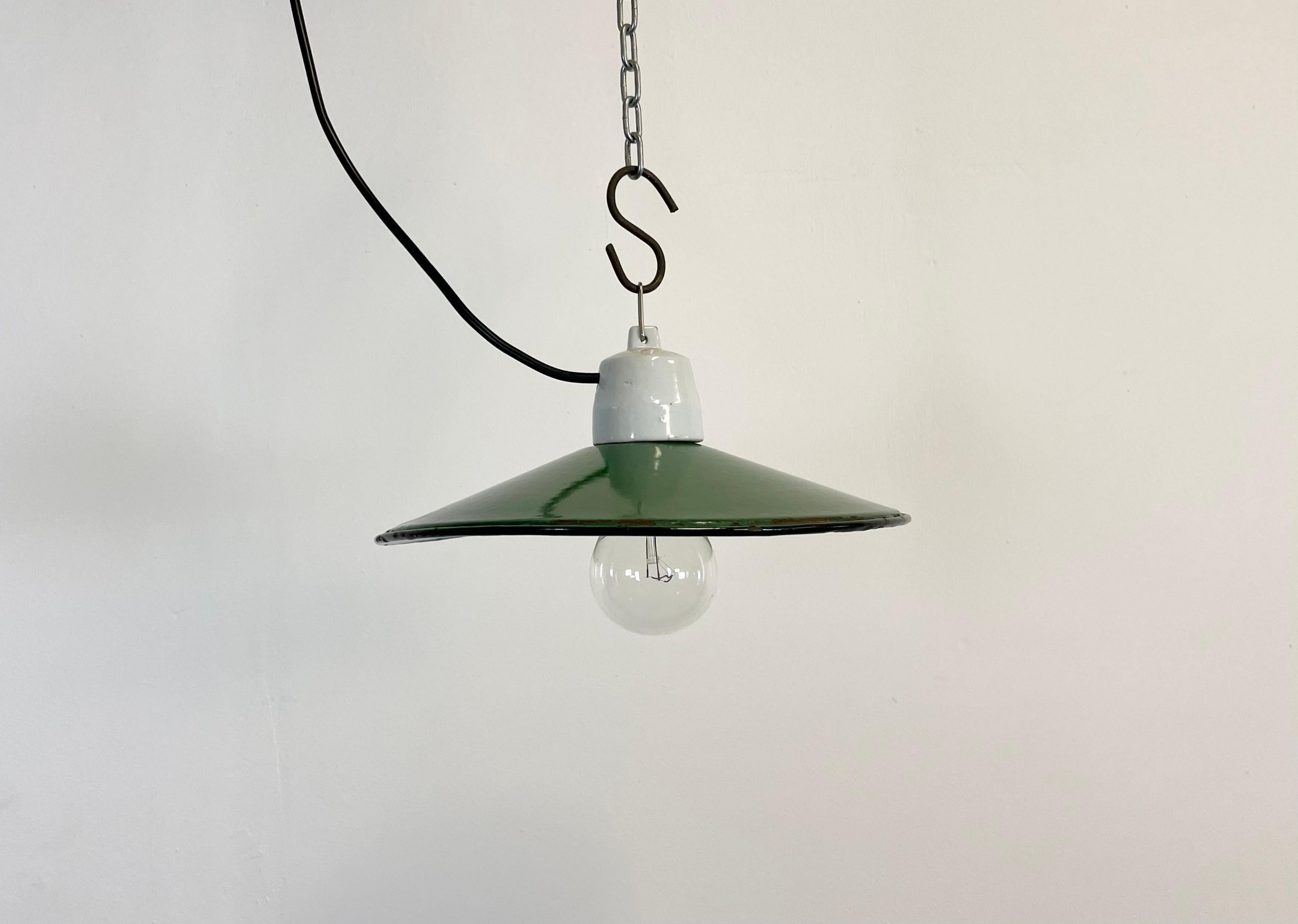 Vintage industrial enamel pendant lamp made in Poland during the 1970s. It features a green enamel shade with white enamel interior and porcelain top. The socket requires E 27 light bulbs. The weight of the lamp is 0,5 kg. New wire.