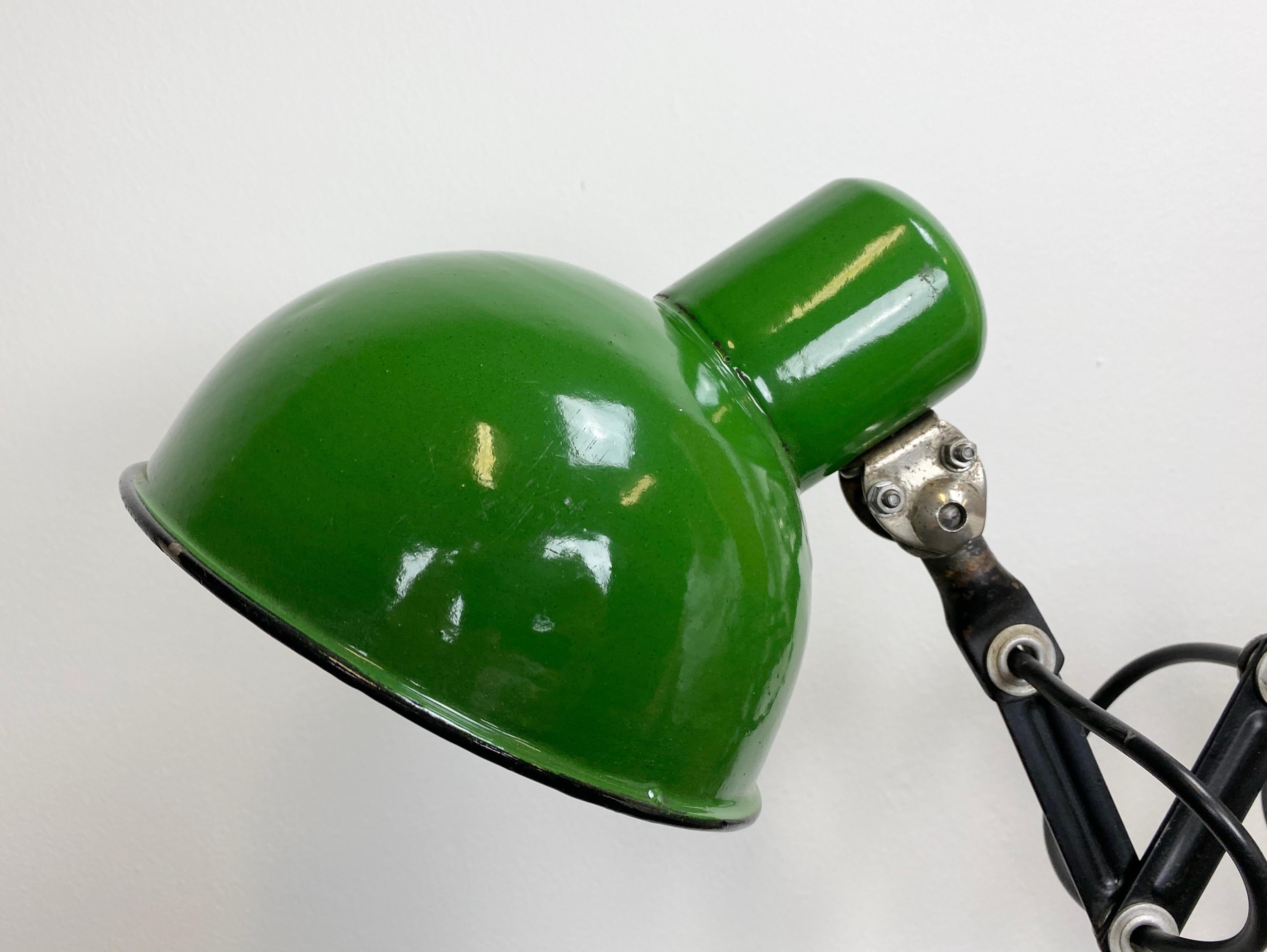 - Industrial scissor lamp was produced in former Czechoslovakia during the 1950s
- The lamp has a green enamel metal shade, white interior
- The black scissor arm is extendable and can be turned sideways
- New porcelain socket for E 27 light