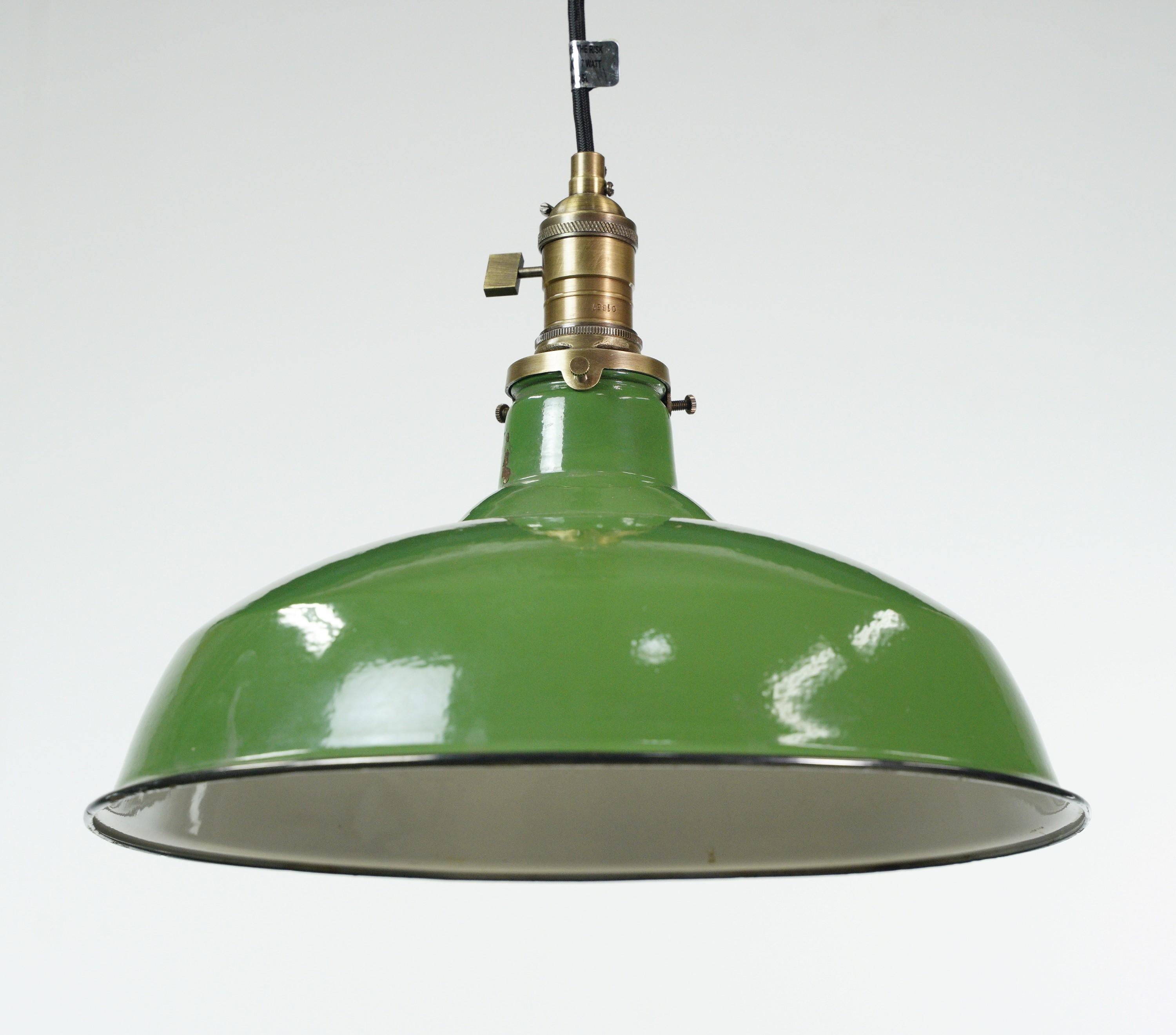 Industrial pendant light featuring a vintage green and white enameled steel shade with a newly made black cord and antique brass finished fitter. This unique blend of materials and finishes creates a bold statement piece that combines vintage charm