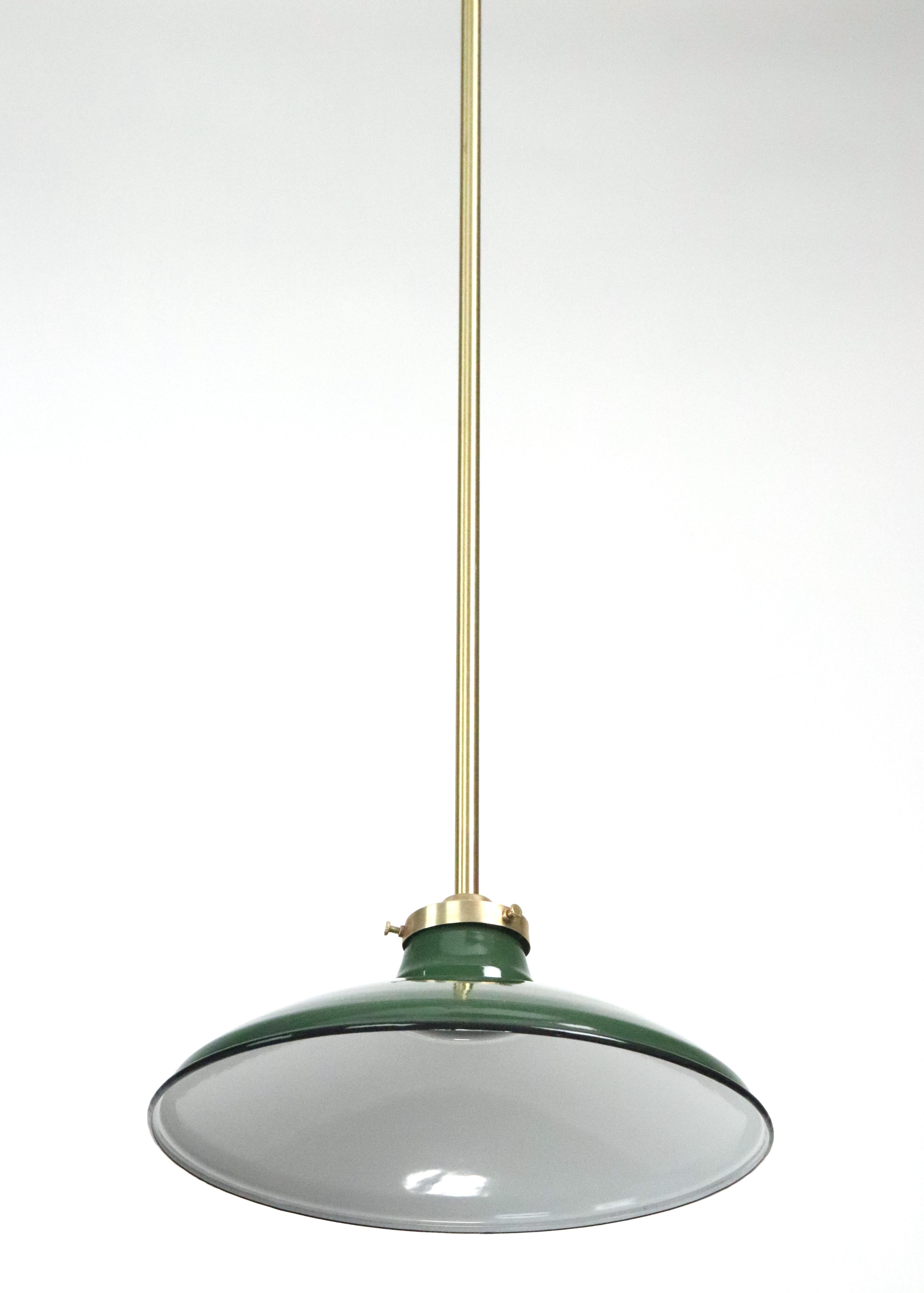 Industrial style pendant light with an enameled green steel shade with a black rim paired with a brushed brass finish steel pole fitter. This requires one standard Edison style medium base bulb. This light is cleaned and restored. Good condition.