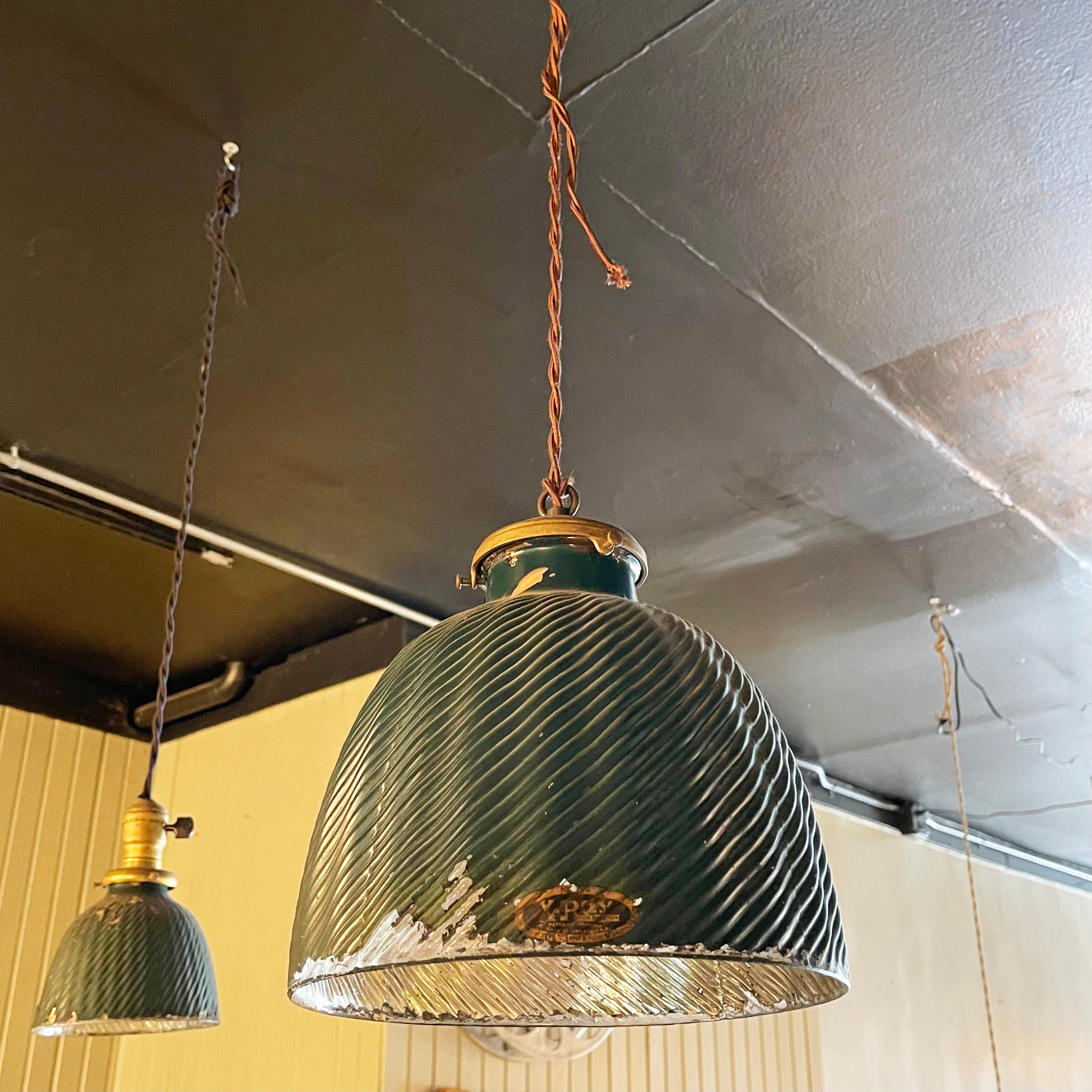 Antique, industrial pendant light features a beautifully patinated, X-Ray mercury glass shade with painted green exterior and reflective silver interior with brass fitter. The lamp is newly wired with 36 inches of braided brown cloth cord to accept