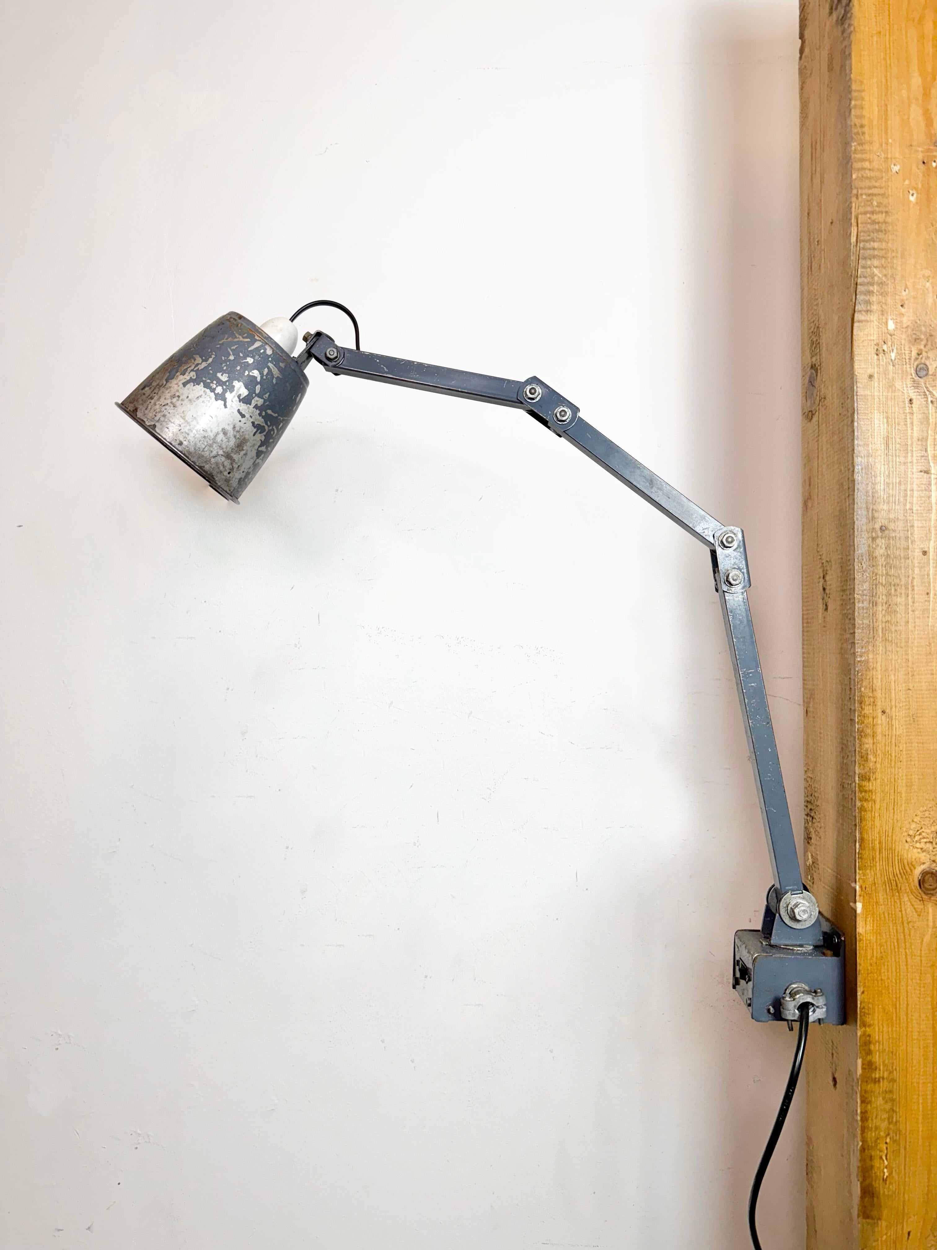 Questa lampada da parete regolabile vintage Industrial è stata prodotta da Memlite nel Regno Unito negli anni '60. Il braccio in ferro ha quattro snodi regolabili e può essere girato lateralmente. L'interruttore originale si trova sul supporto a