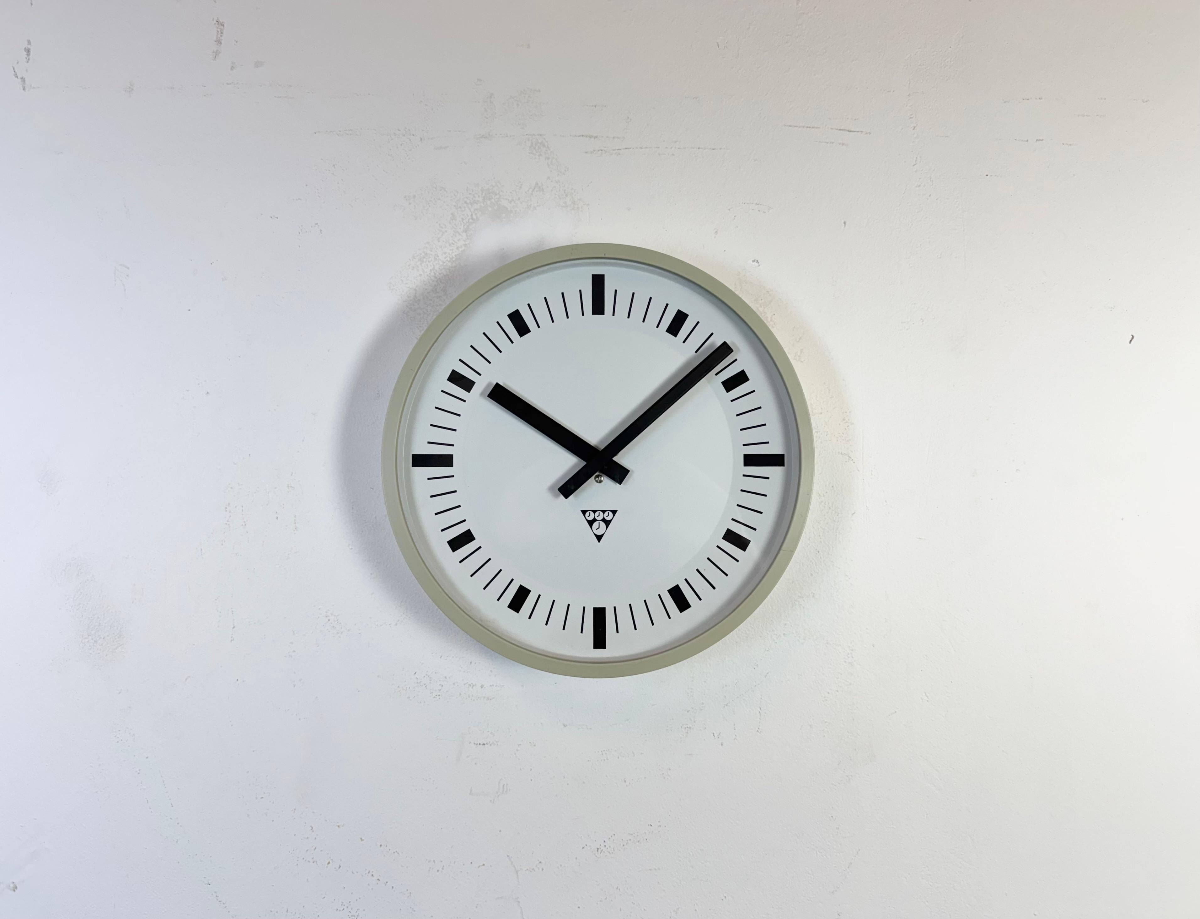 Horloge murale produite par Pragotron dans l'ancienne Tchécoslovaquie dans les années 1970-1980. La pièce est composée d'un cadre en bakélite grise, d'un cadran en aluminium et d'un couvercle en verre transparent. La pièce a été convertie en un