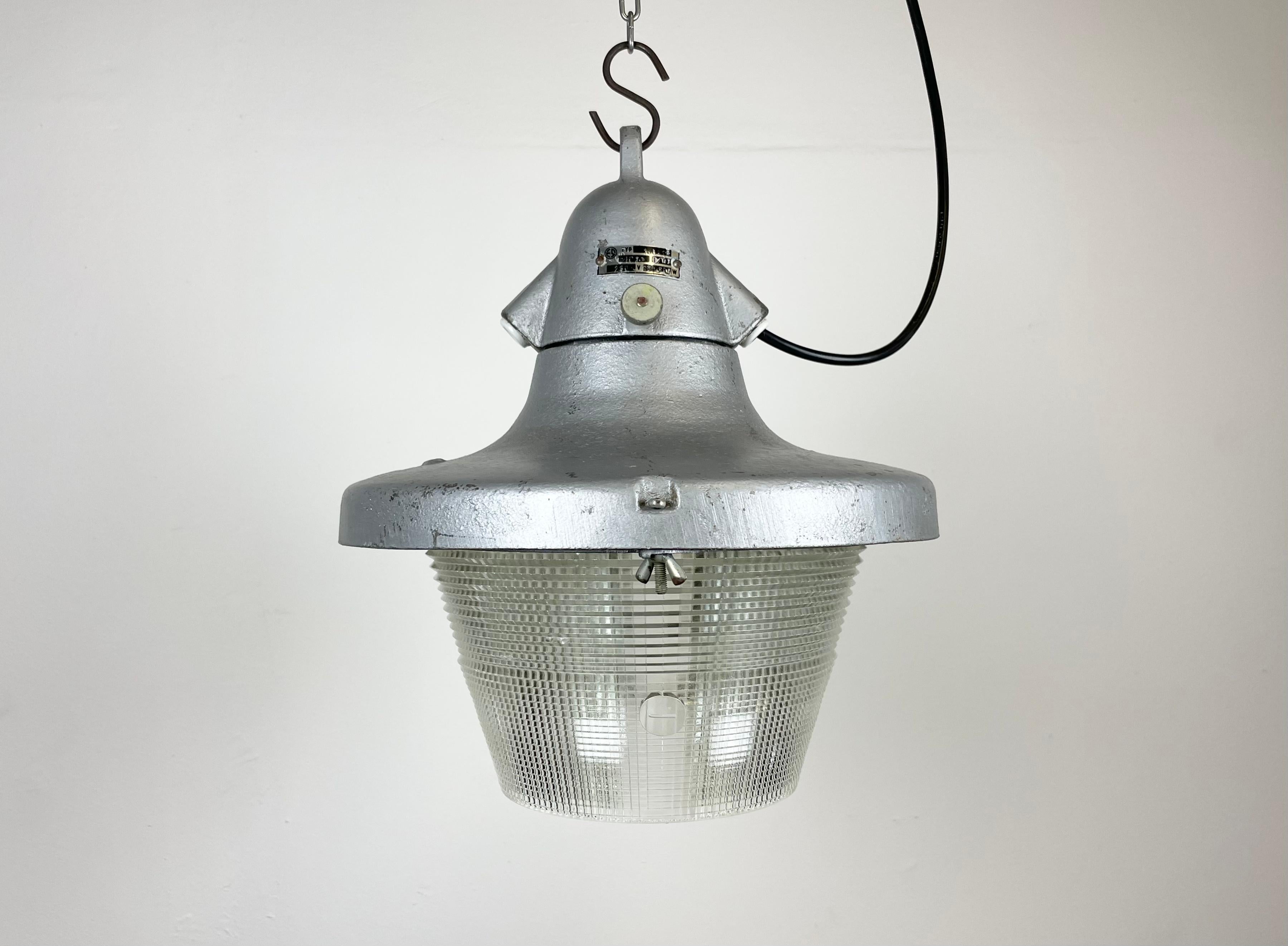 Industrial light made by Elektrosvit in former Czechoslovakia during the 1950s. It features a cast aluminium body and a striped glass cover.
The porcelain socket requires standard E27/ E26 lightbulbs. New wire. The weight of the lamp 4,2 kg. The
