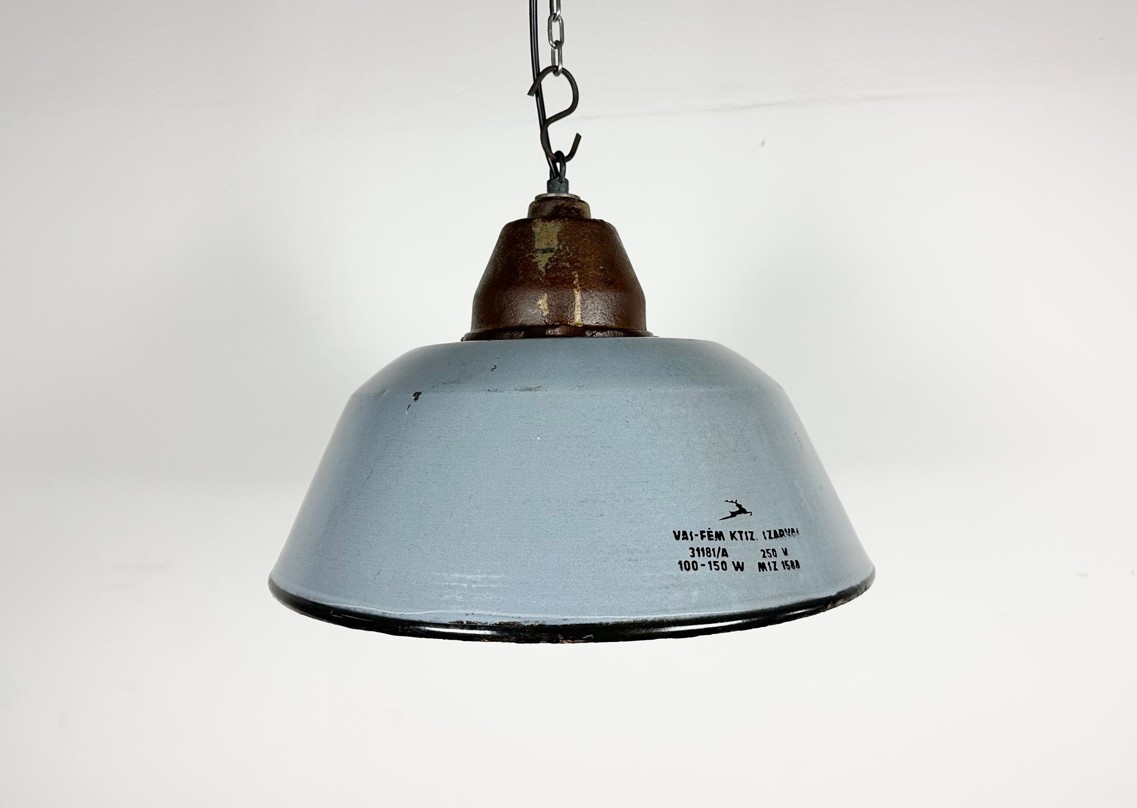 Industrial hanging lamp manufactured by Szarvasi Vas - Fém in Hungary during the 1960s. It features a grey enamel shade, white enamel interior and a cast iron top. New porcelain socket requires E 27/ E26 light bulbs. New wire. The diameter of the