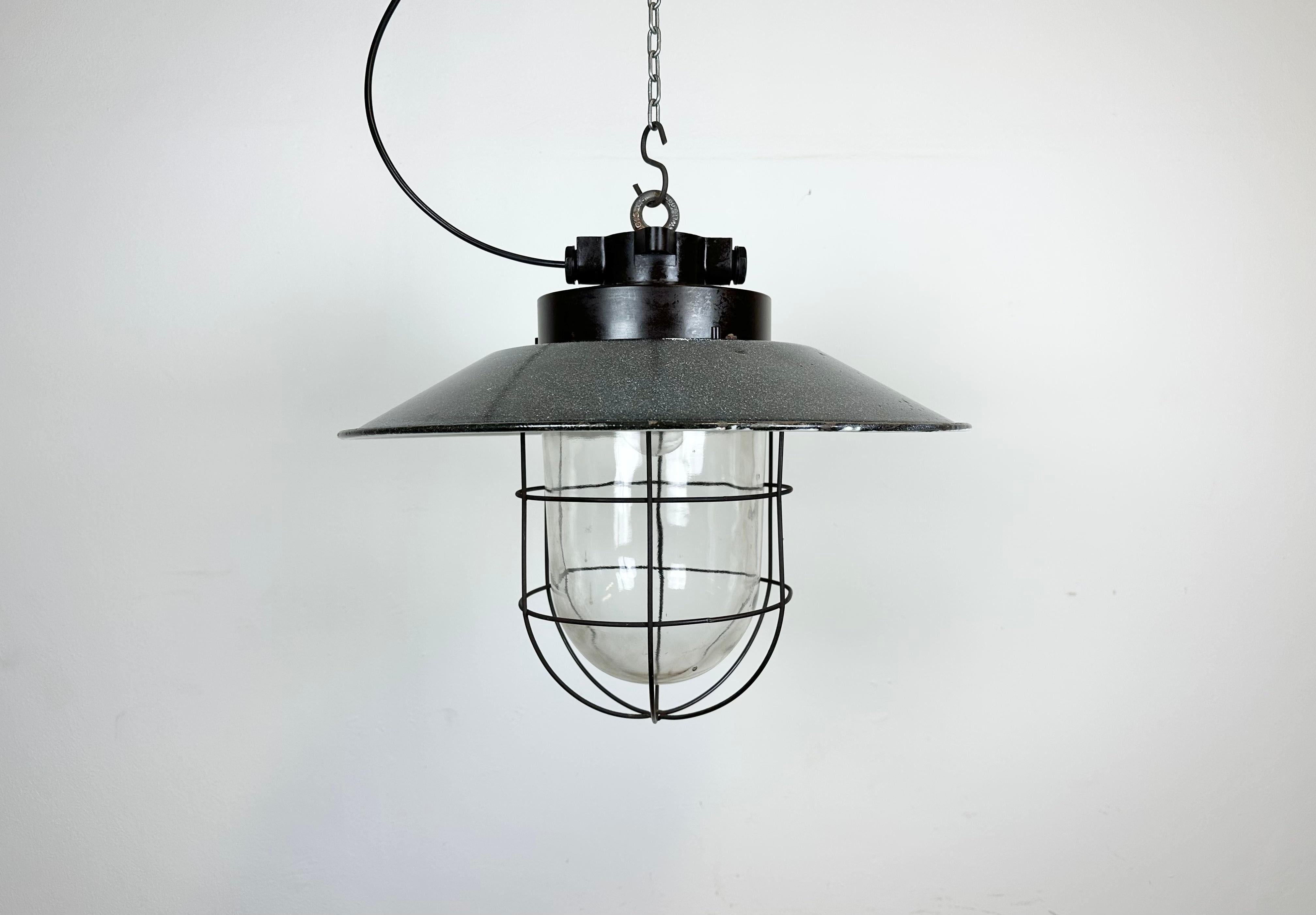 - Vintage industrial light from former Czechoslovakia made during the 1960s
- Grey enamel shade with white interior
- Bakelite top
- Clear glass, iron grid
- Porcelain socket requires E 27/ E26 lightbulbs
- New wire
- Weight: 3.2 kg.
 