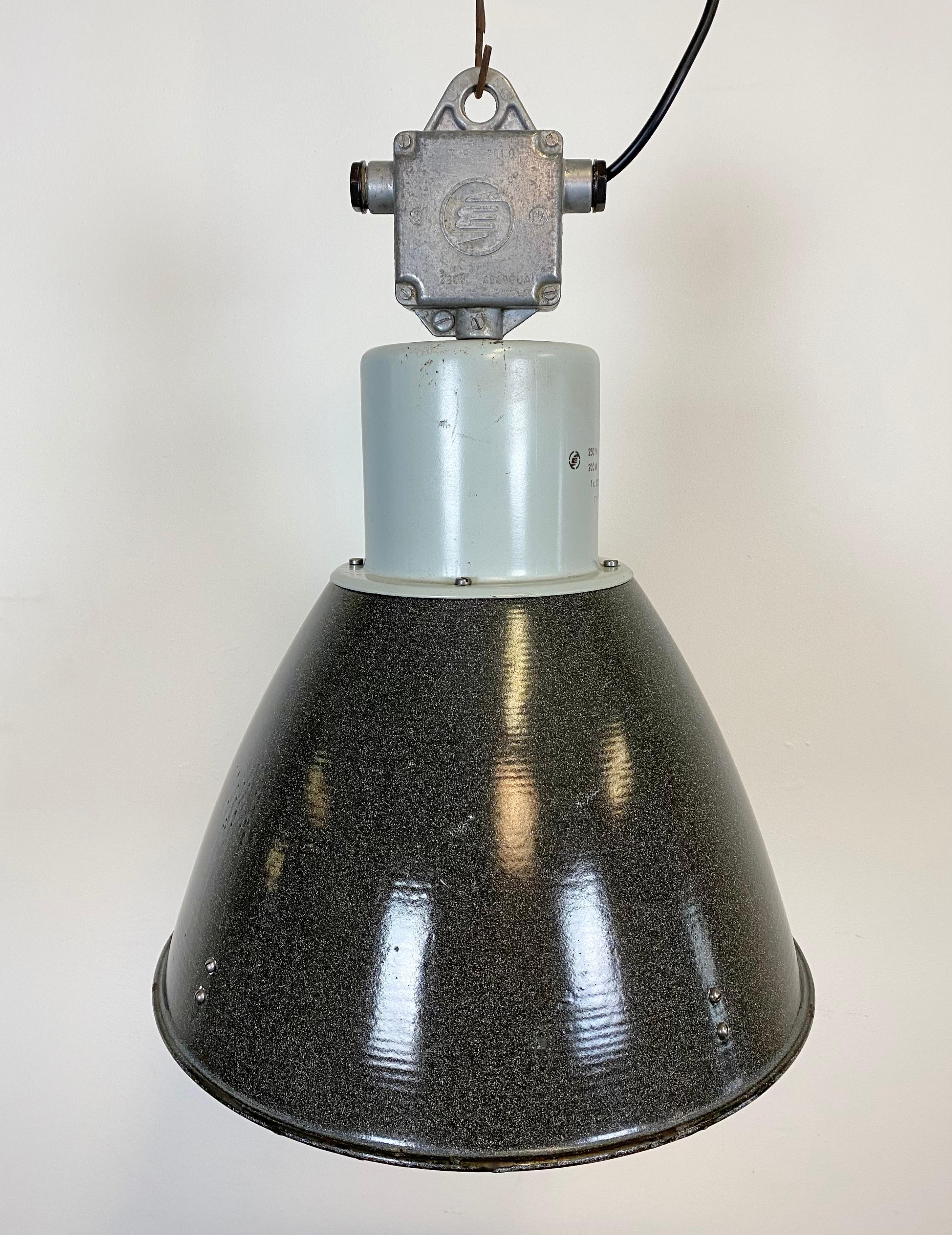 This grey enamel pendant lamp was designed in the 1960s and produced by Elektrosvit in the former Czechoslovakia. It features a grey metal top with a cast aluminium box, a dark grey enamel shade with a white enamel interior. The lamp has new