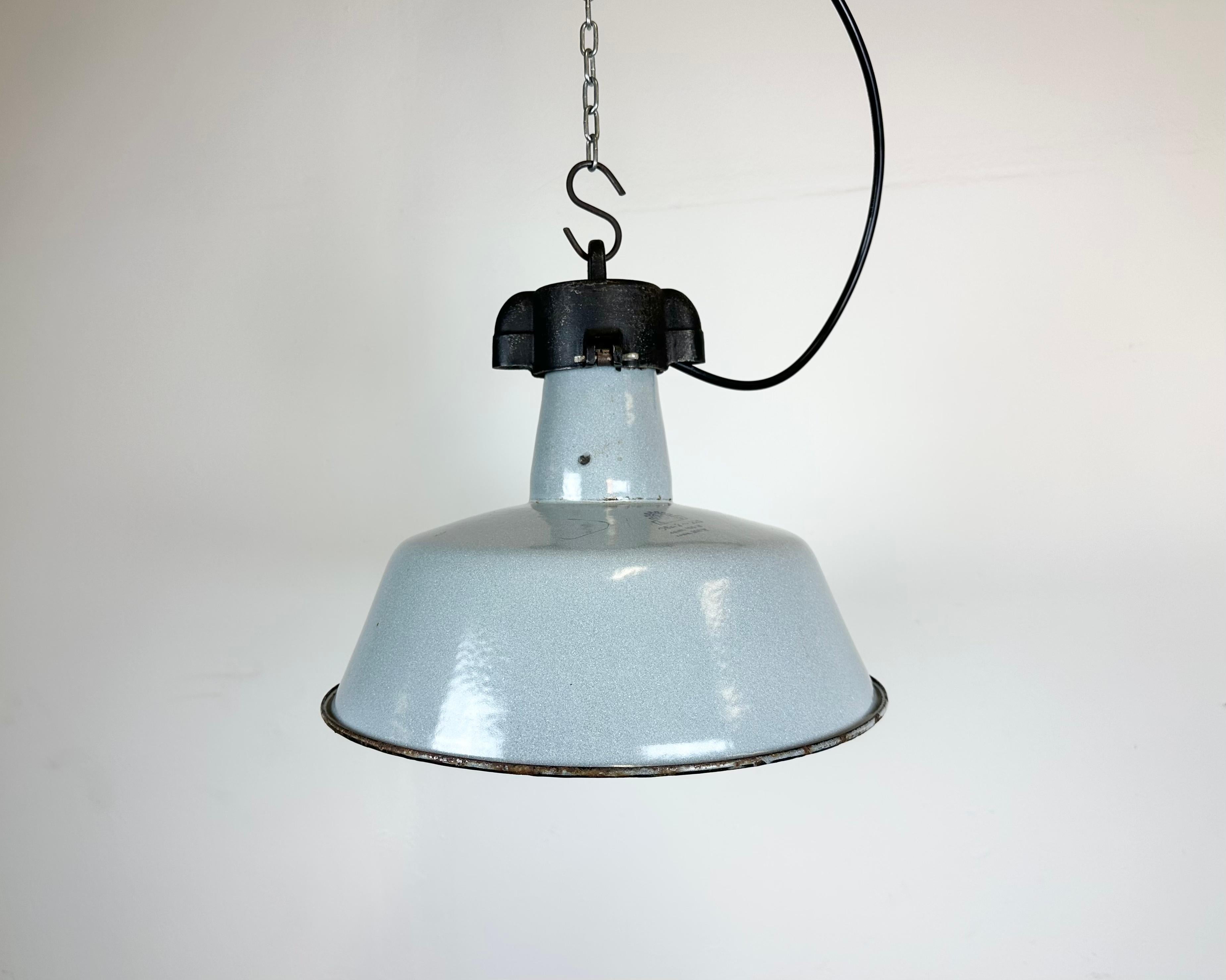 Industrial grey enamel pendant light made by Polam Wilkasy in Poland during the 1960s. White enamel inside the shade. Cast iron top. The porcelain socket requires E 27/ E 26 light bulbs. New wire. Fully functional. The weight of the lamp is 2 kg.