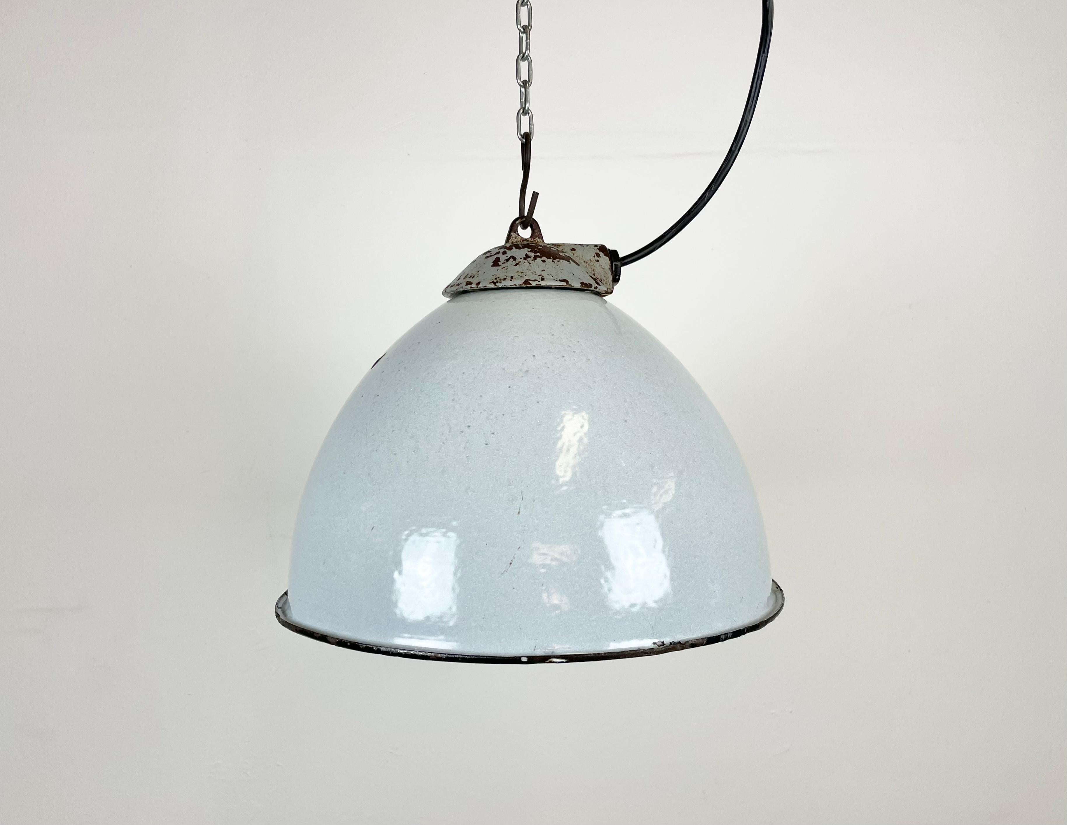 Industrial grey enamel pendant light made by Zaos in Poland during the 1960s. White enamel inside the shade. Cast iron top. The porcelain socket requires E 27 light bulbs. New wire. Fully functional. The weight of the lamp is 1,8 kg.
