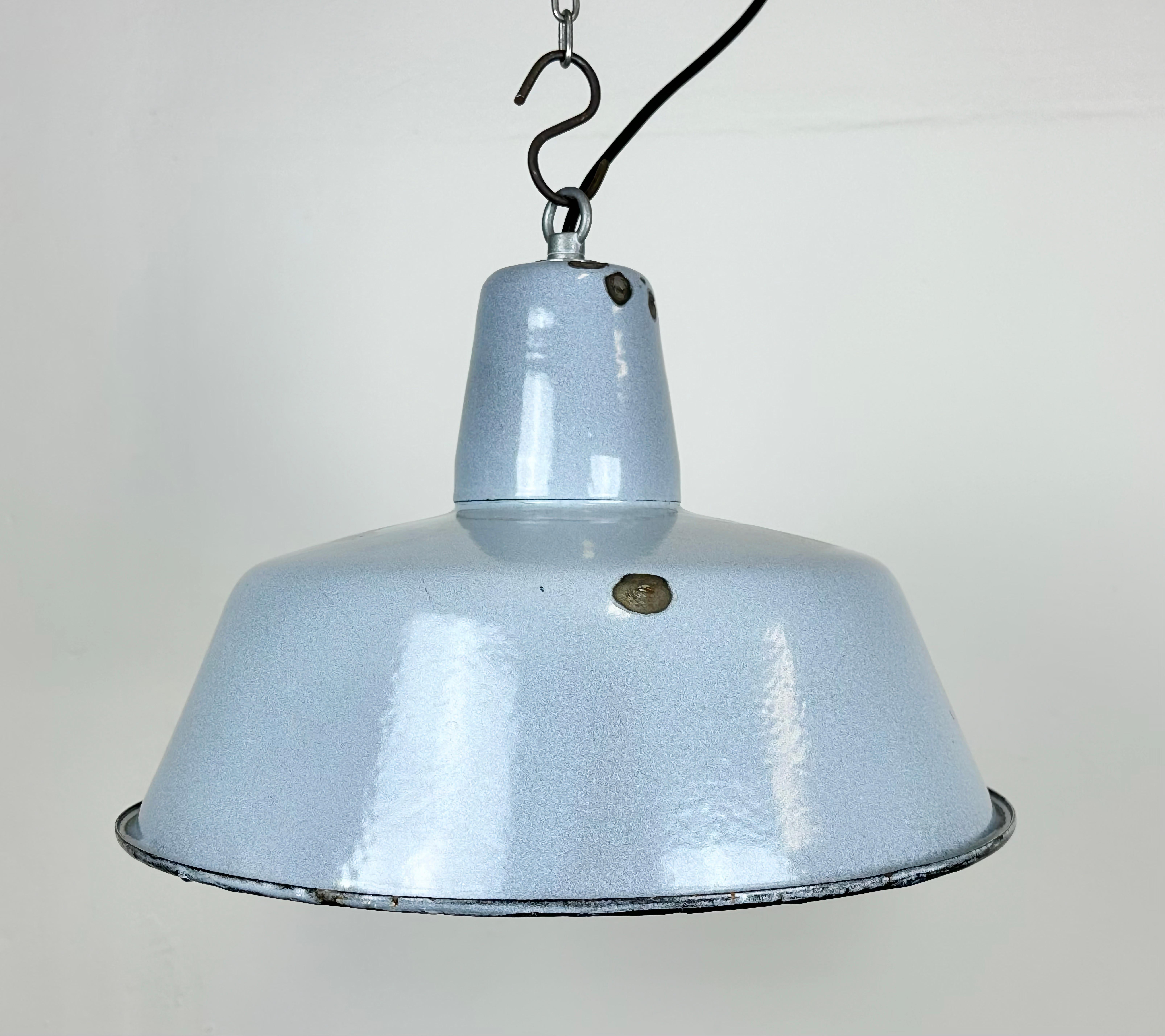 Industrial grey enamel pendant light made in Poland during the 1960s. White enamel inside the shade. Iron top. The porcelain socket requires E 27/ E 26 light bulbs. New wire. Fully functional. The weight of the lamp is 1,2 kg.