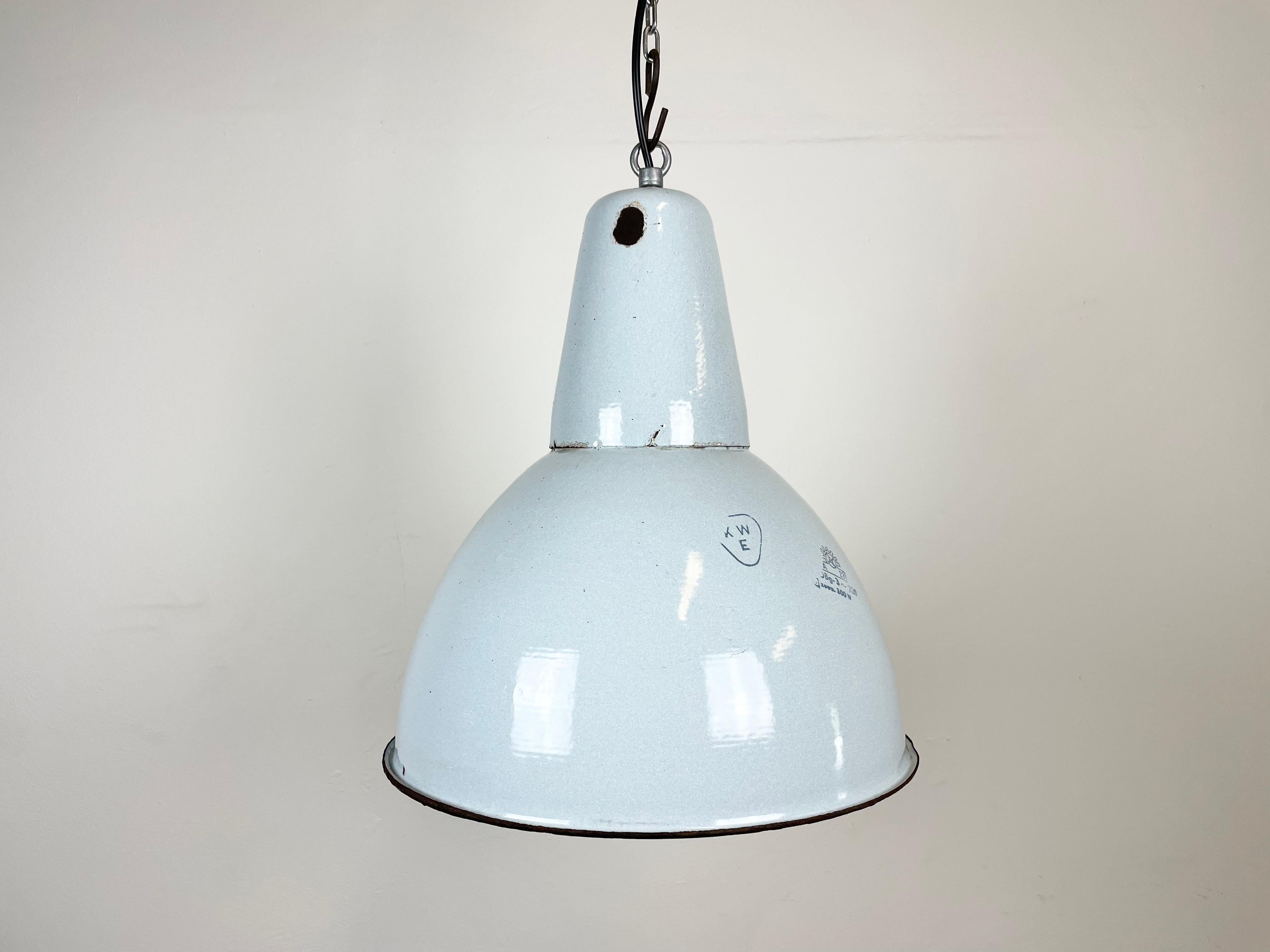 Industrial grey enamel pendant light made by Polam Wilkasy in Poland during the 1960s. White enamel inside the shade. Iron top. The porcelain socket requires E 27/ E26 light bulbs. New wire. Fully functional. The weight of the lamp is 1,6 kg.
