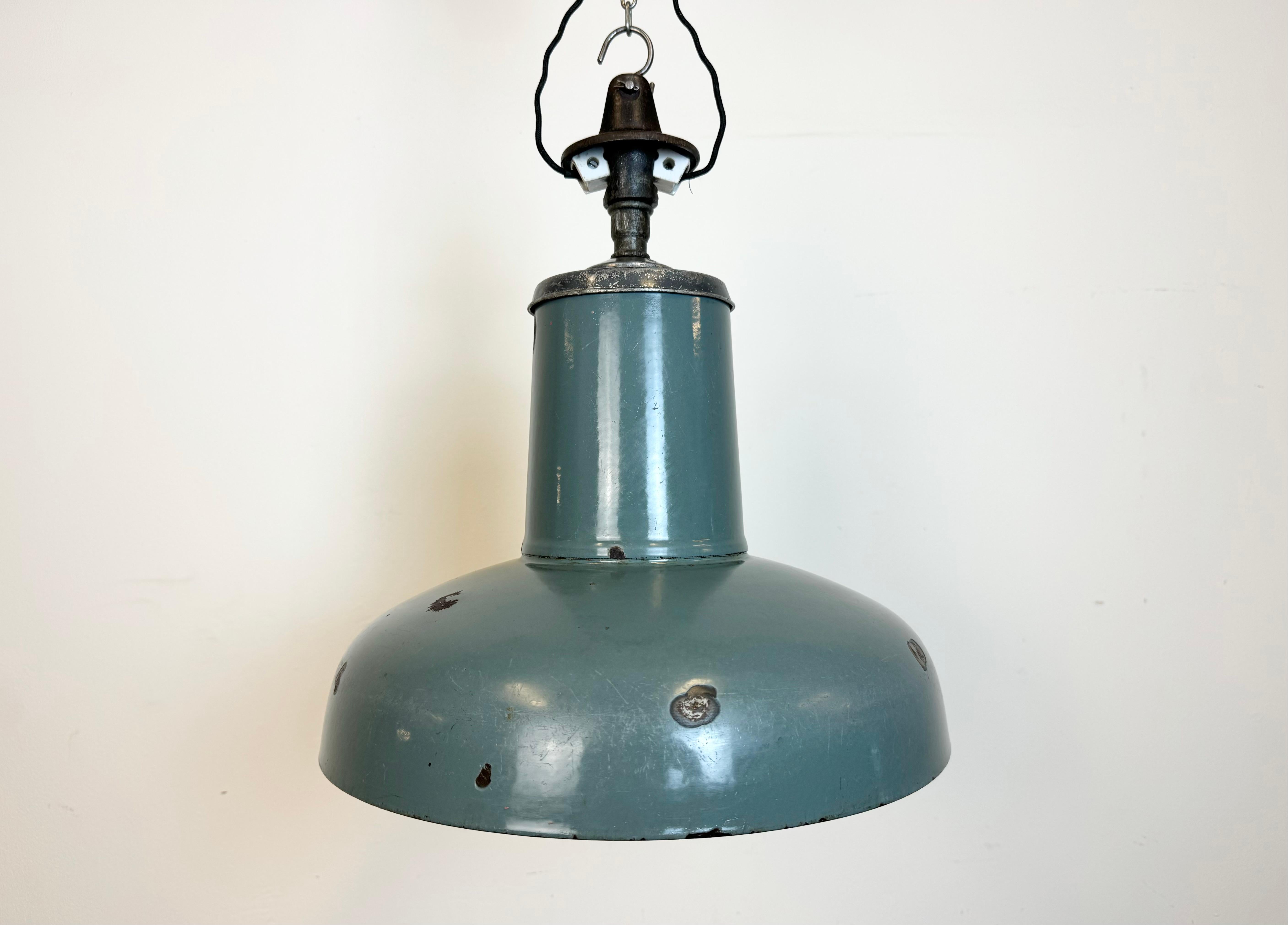 Industrial grey enamel pendant light made by Siemens in Germany during the 1930s. White enamel inside the shade. Cast iron top. The porcelain socket requires standard E 27/ E26 light bulbs. New wire. Fully functional. The weight of the lamp is 2,6