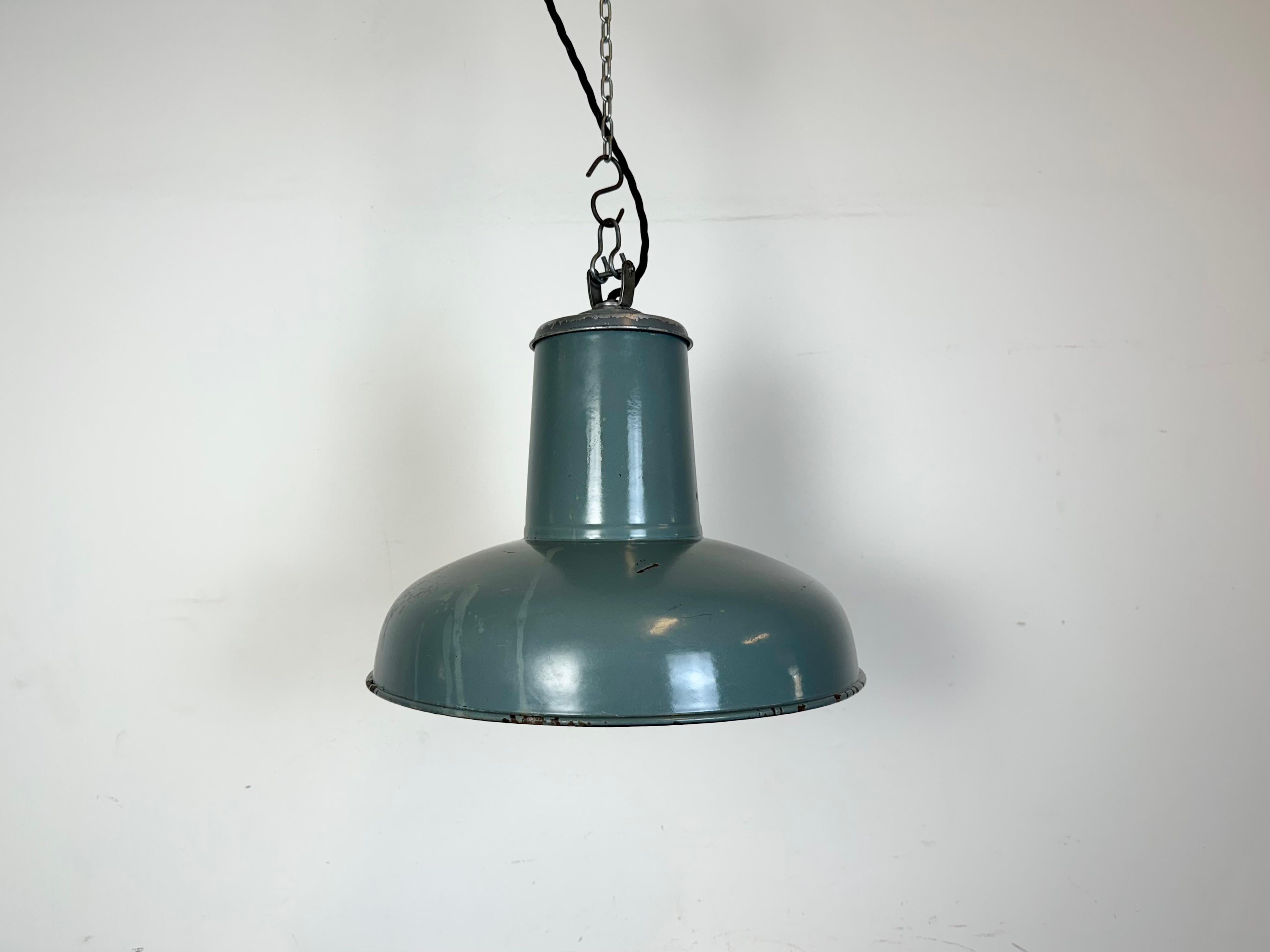 Industrial grey enamel pendant light made by Siemens in Germany during the 1930s. White enamel inside the shade. Iron top. The porcelain socket requires standard E 27/ E26 light bulbs. New wire. Fully functional. The weight of the lamp is 2,2 kg. 