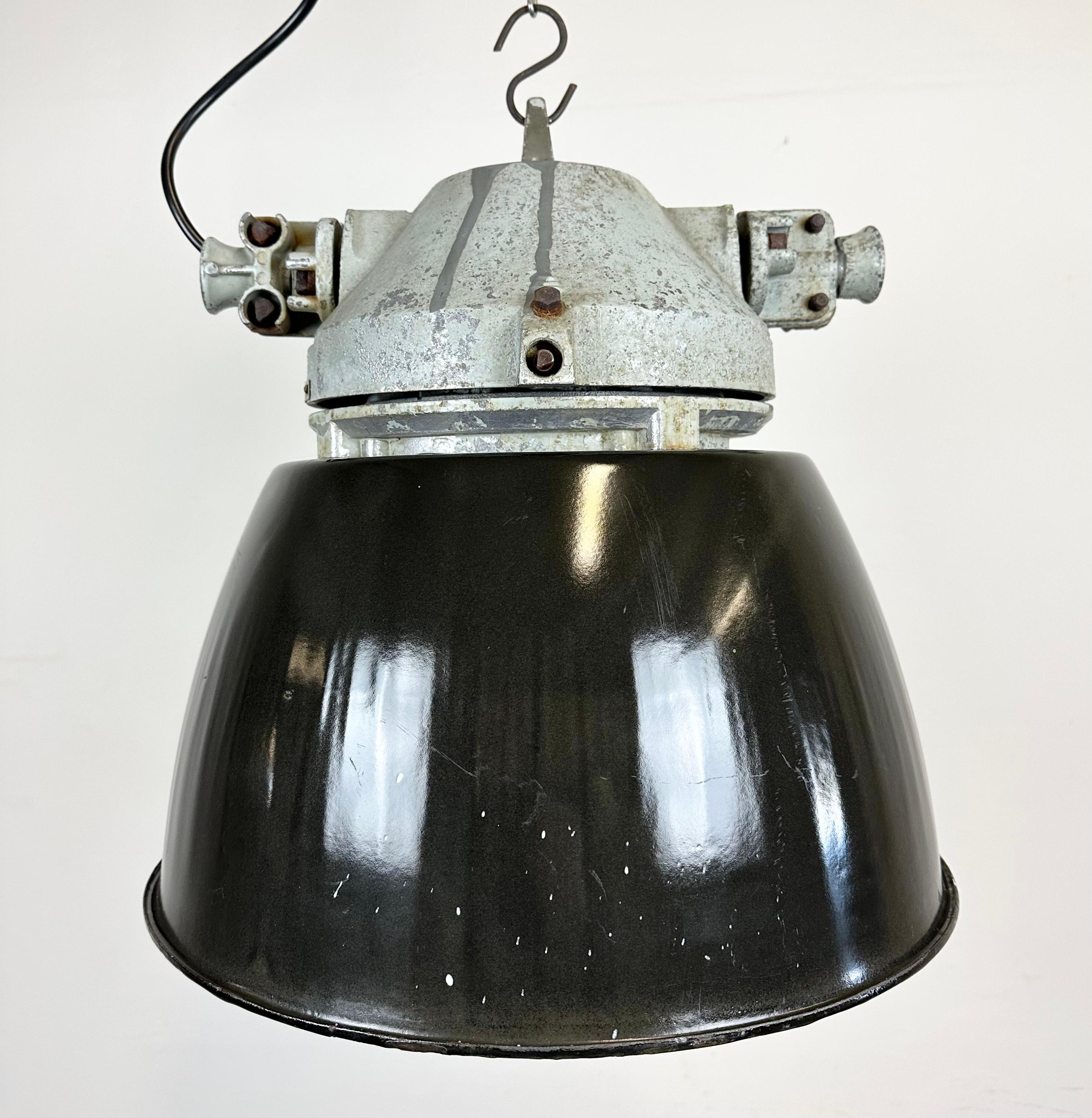 Grey industrial light with massive protective glass bulb. Cast aluminium body, clear glass. Black enameled shade with white interior. The socket requires E27/ E26 light bulbs. Newly wired. Weight: 9 kg.