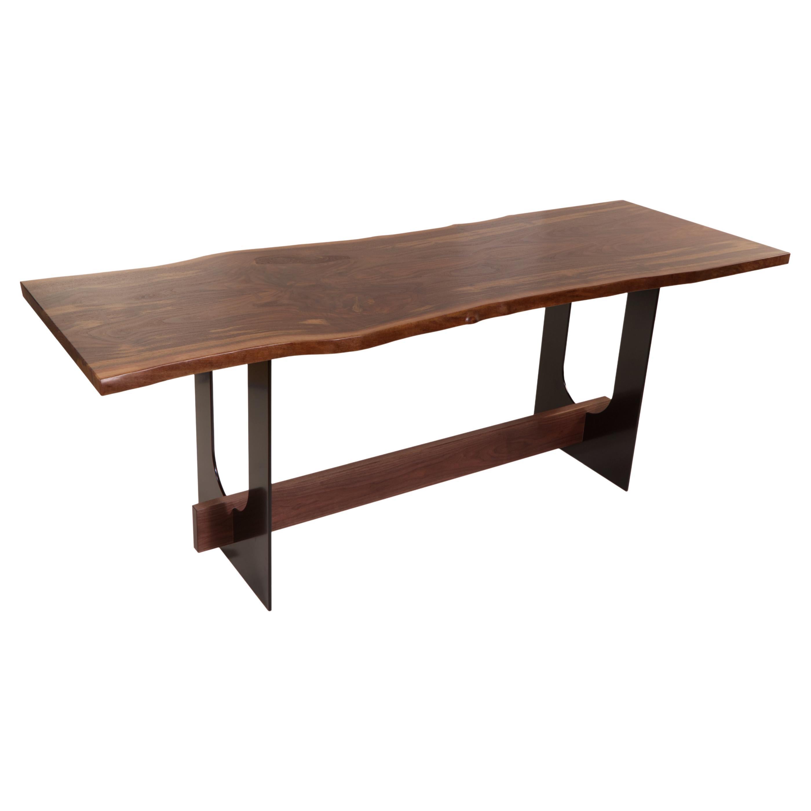 Industriell und raffiniert - diese beiden Worte beschreiben den Menlo Table treffend. Mit einer Platte aus schönem Nussbaumholz, die auf einem Paar massiver Stahlbeine ruht, passt dieses schlichte Design in jeden Raum, von ganz modern bis rustikal.