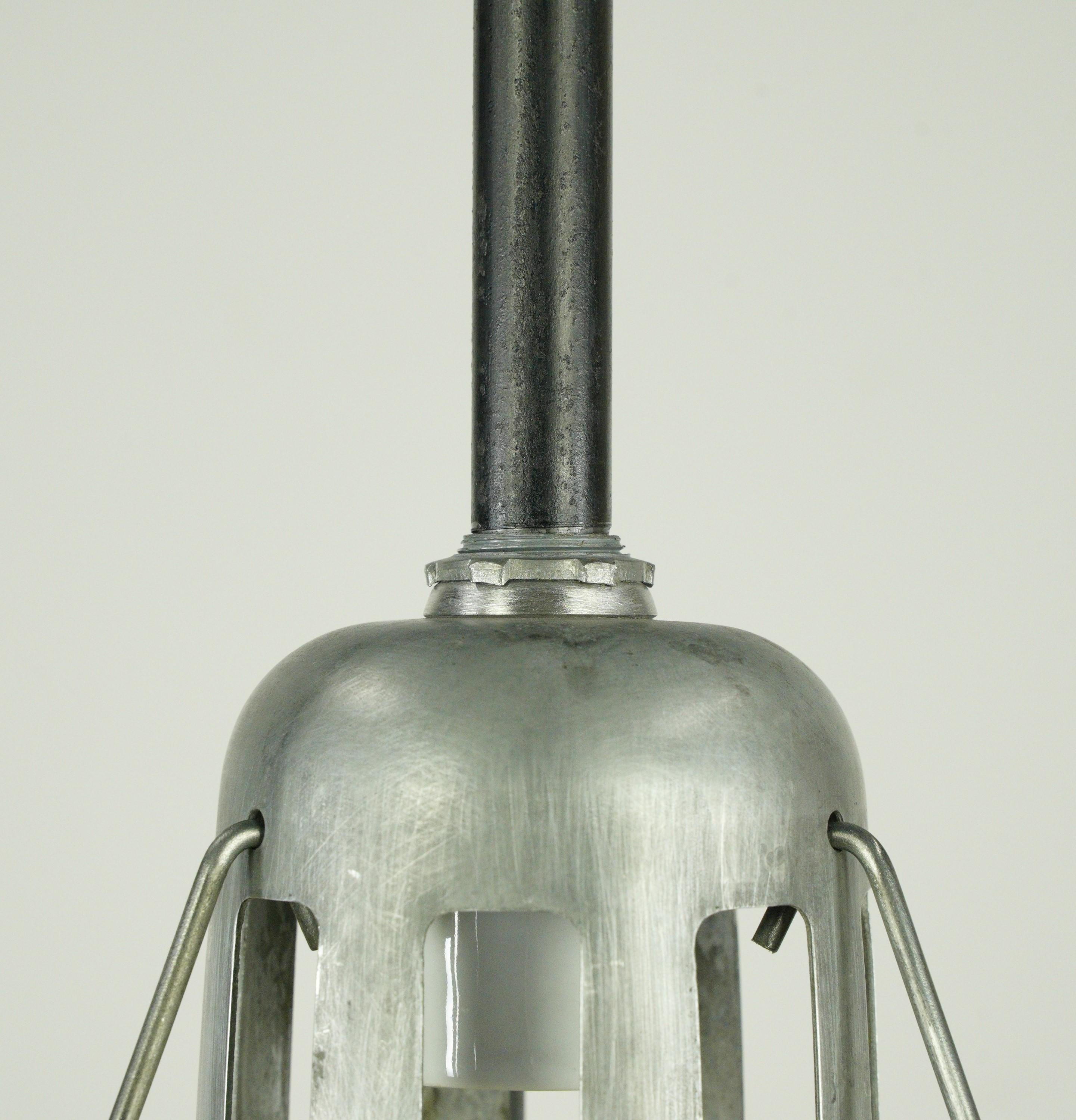 Industrial factory pendant light with a clear holophane glass shade and black steel pole construction. The price includes restoration of cleaning and rewiring. Cleaned and restored. Good condition with appropriate wear from age. Small quantity