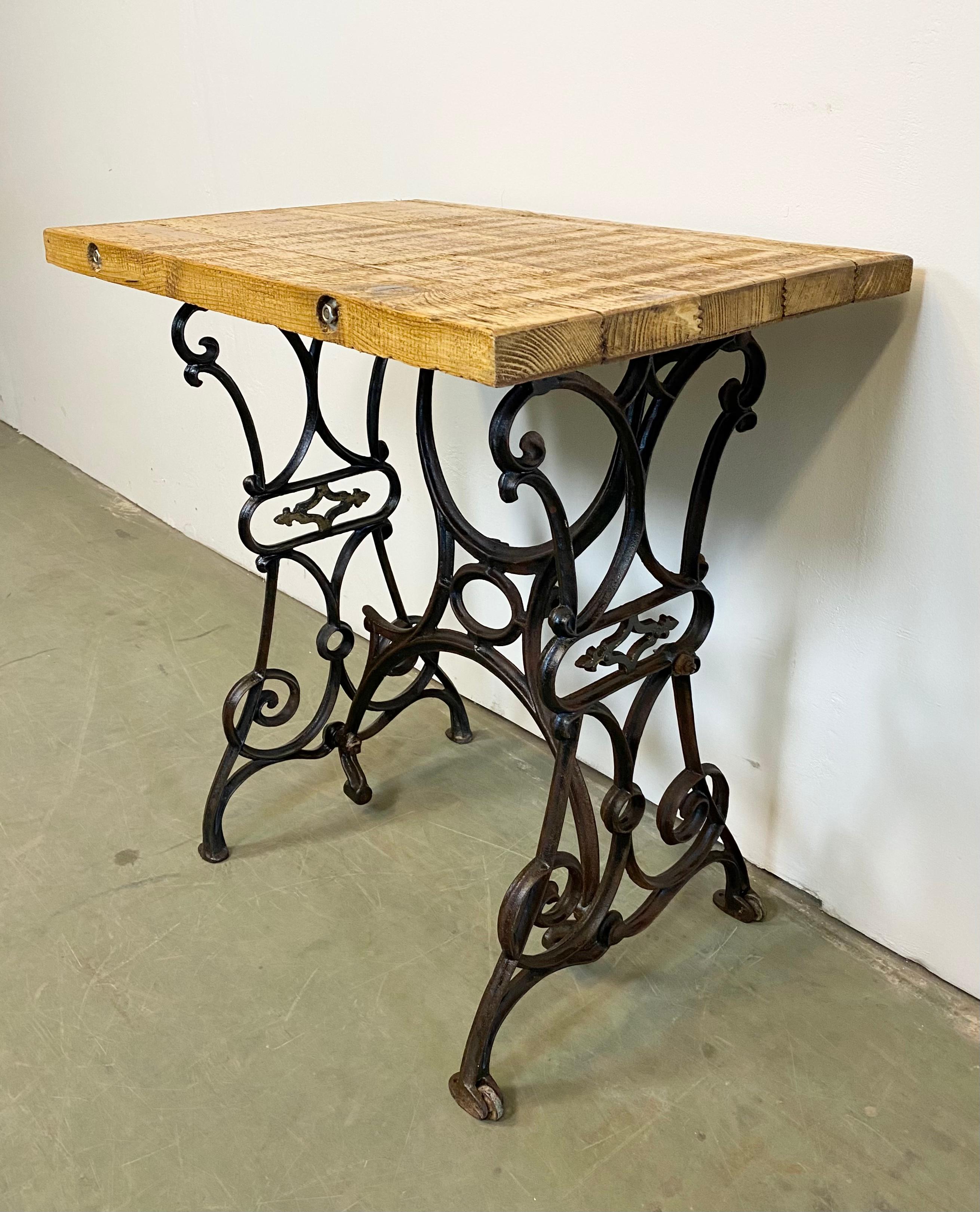 This industrial table comes from the 1950s. The old wooden top was recently mounted on a former sewing machine cast iron base. The weight of the table is 23 kg.