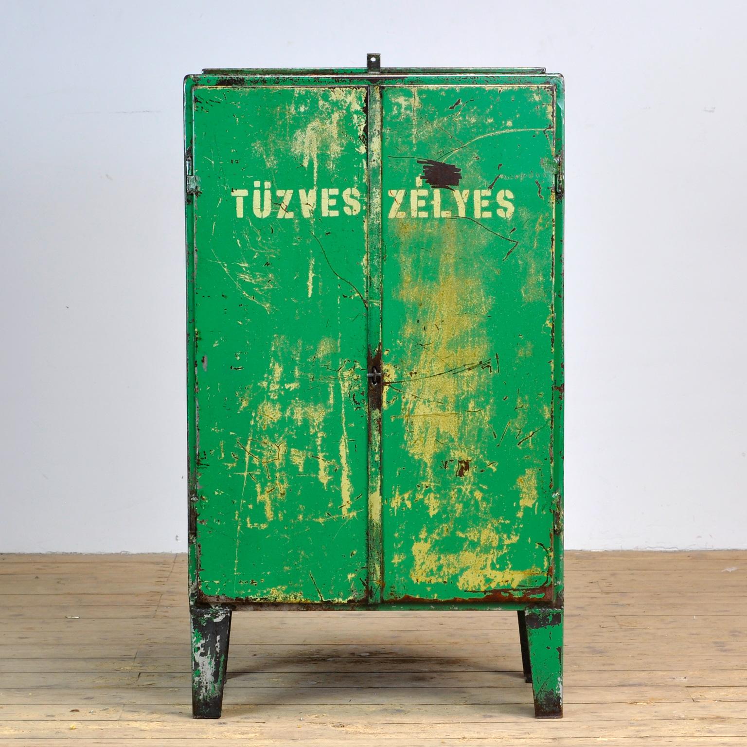 Iron industrial sideboard in nice vintage condition. Made of metal. With a valve on top. One shelve and two drawers on the inside. The text “TÜZVESZÉLYES” printed on the case means FLAMMABLE. Treated for rust and finished with a transparant varnish.