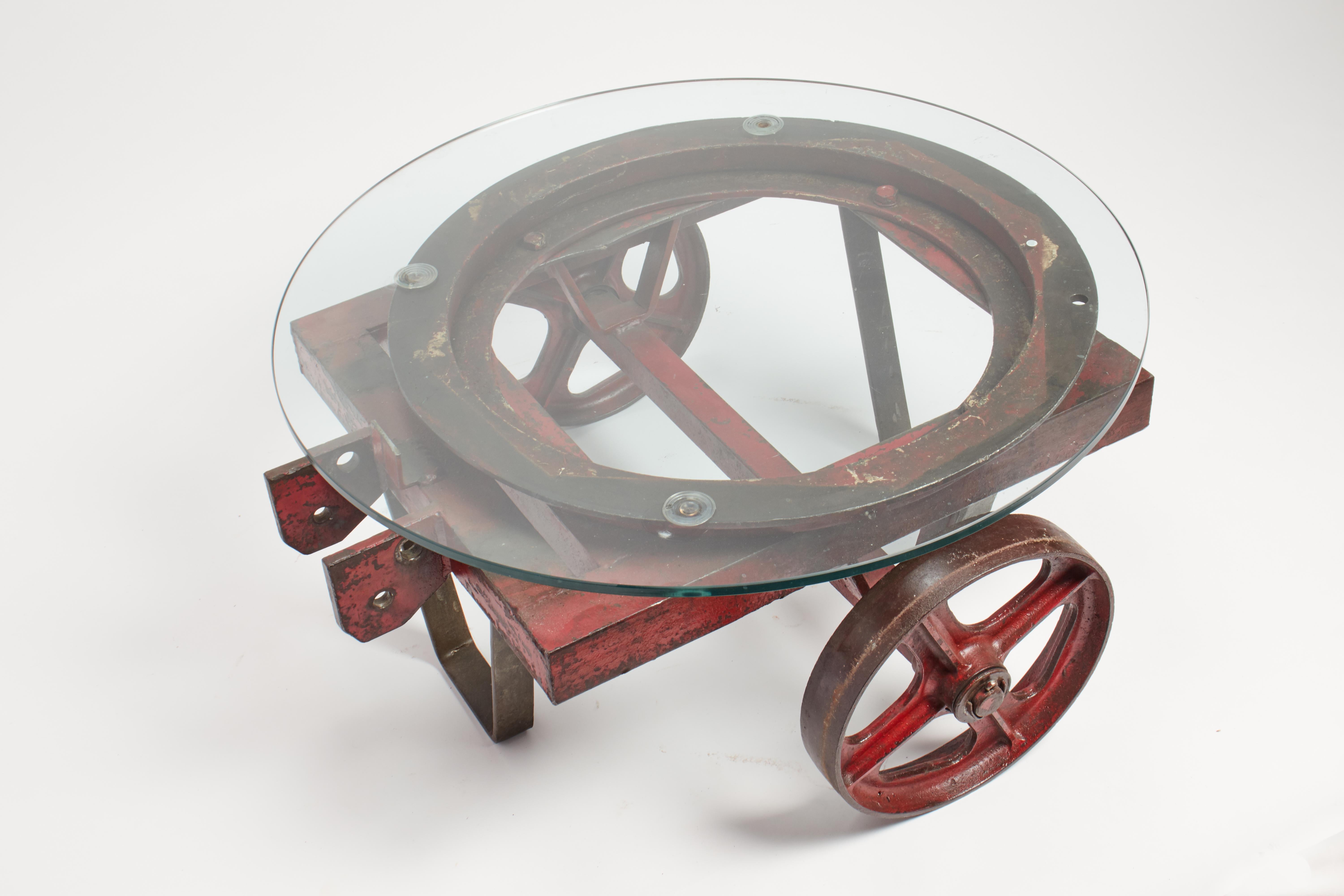 Chariot industriel en fer peint, de couleur rouge, avec une base ronde rotative en verre, 2 roues. Italie 1930 ca.