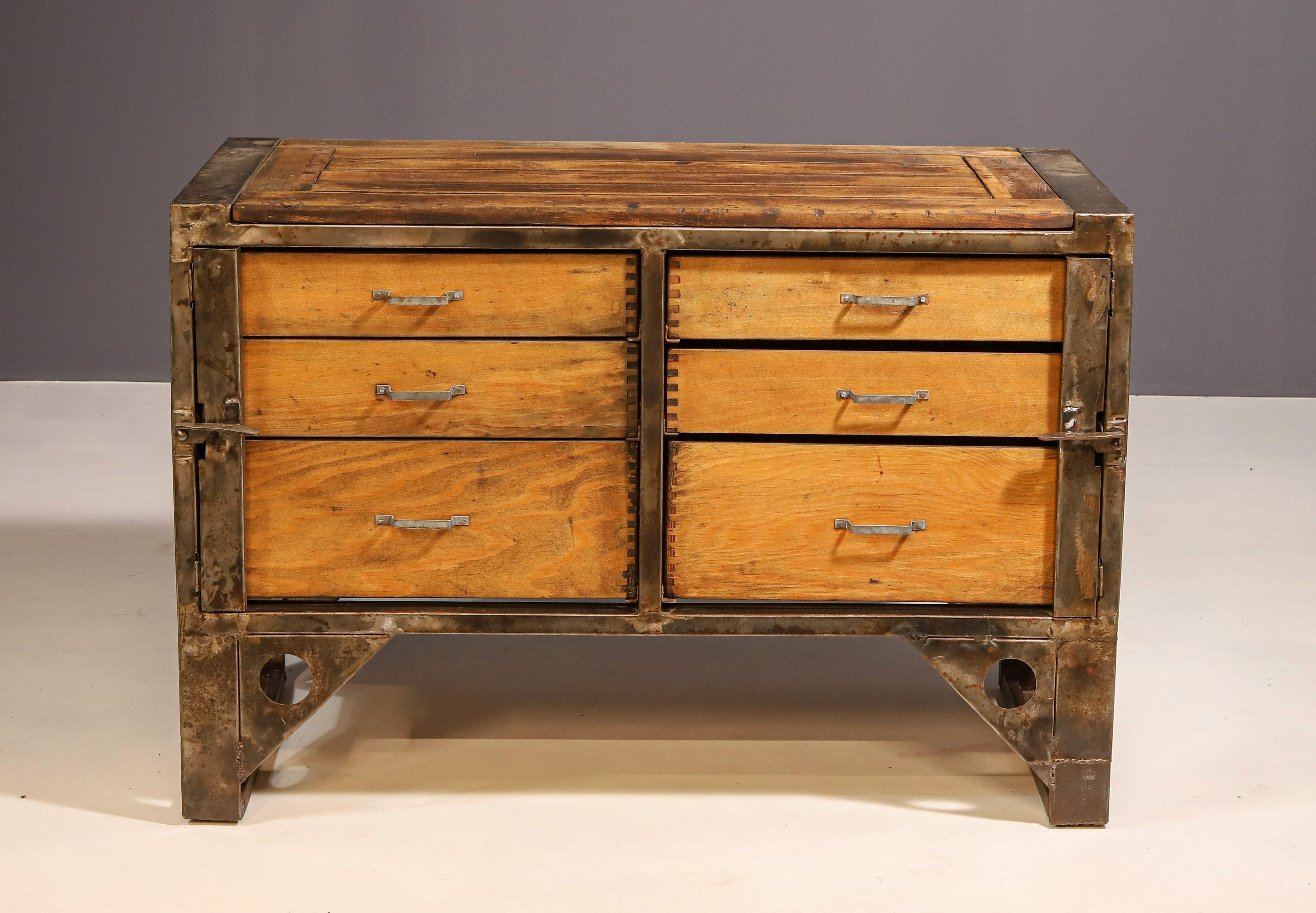 Questa cassettiera industriale è stata realizzata nell'ex Cecoslovacchia negli anni ´1950.

È fatto di ferro e legno. Sotto il piano del tavolo ci sono 6 enormi cassetti.

La cassapanca è complessivamente in ottime condizioni d'epoca, presenta segni