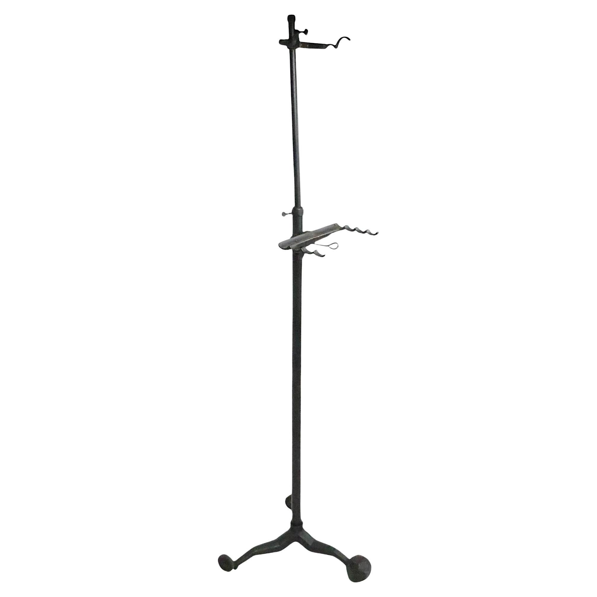 Cavalletto industriale regolabile in ghisa e acciaio, realizzato da L'Ecole Art Co. 1775 Broadway New York, circa 1900/20 anni. Il supporto è dotato di una base a tre gambe, di cui due con ruote e la terza con una sfera sfaccettata, per ancorare il