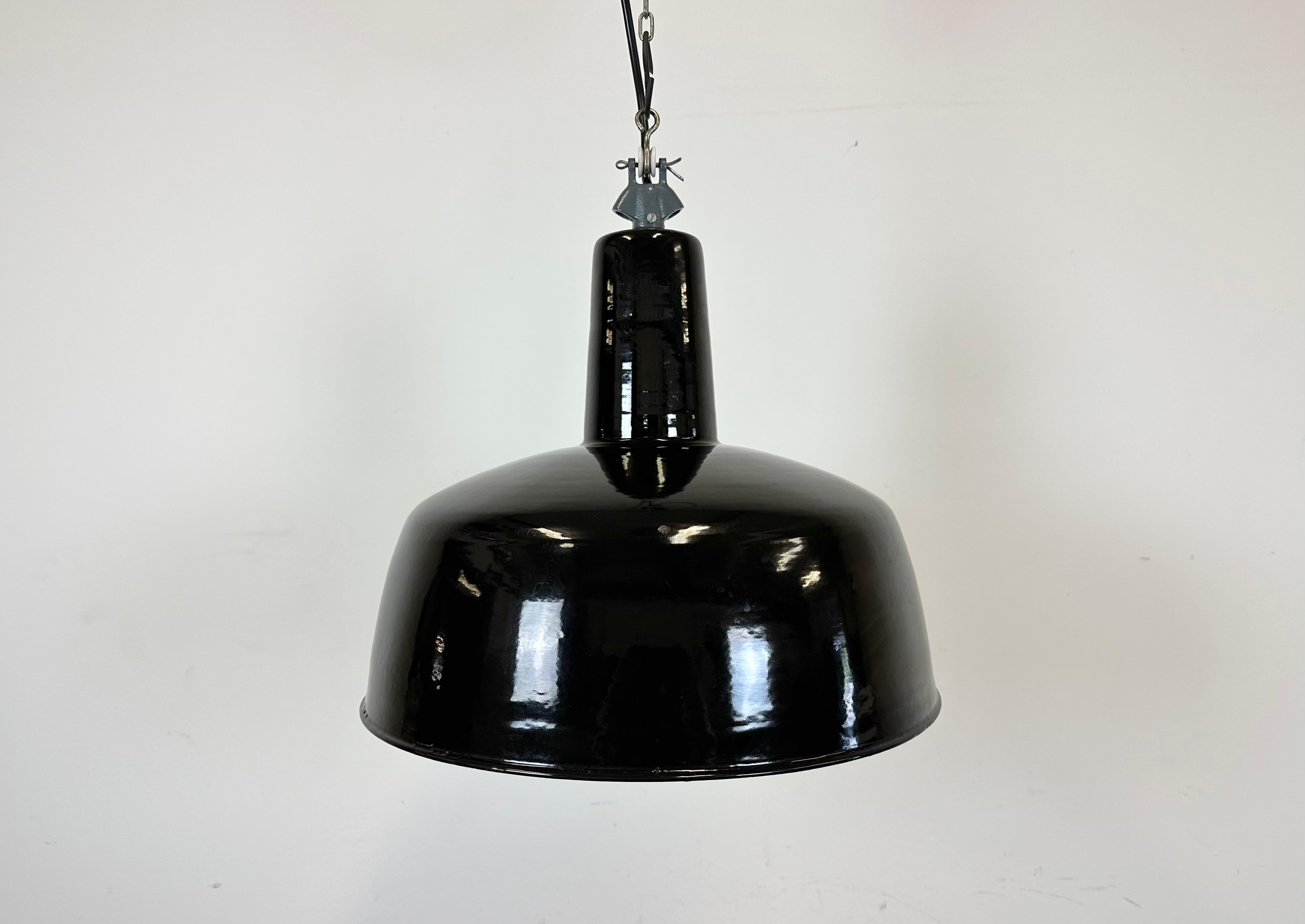 Industrial black enamel factory pendant light made in Italy during the 1960s. White enamel inside the shade. Grey cast iron top. The socket requires standard E 27/ E26 light bulbs. New wire. Fully functional. The weight of the lamp is 2,8 kg.The