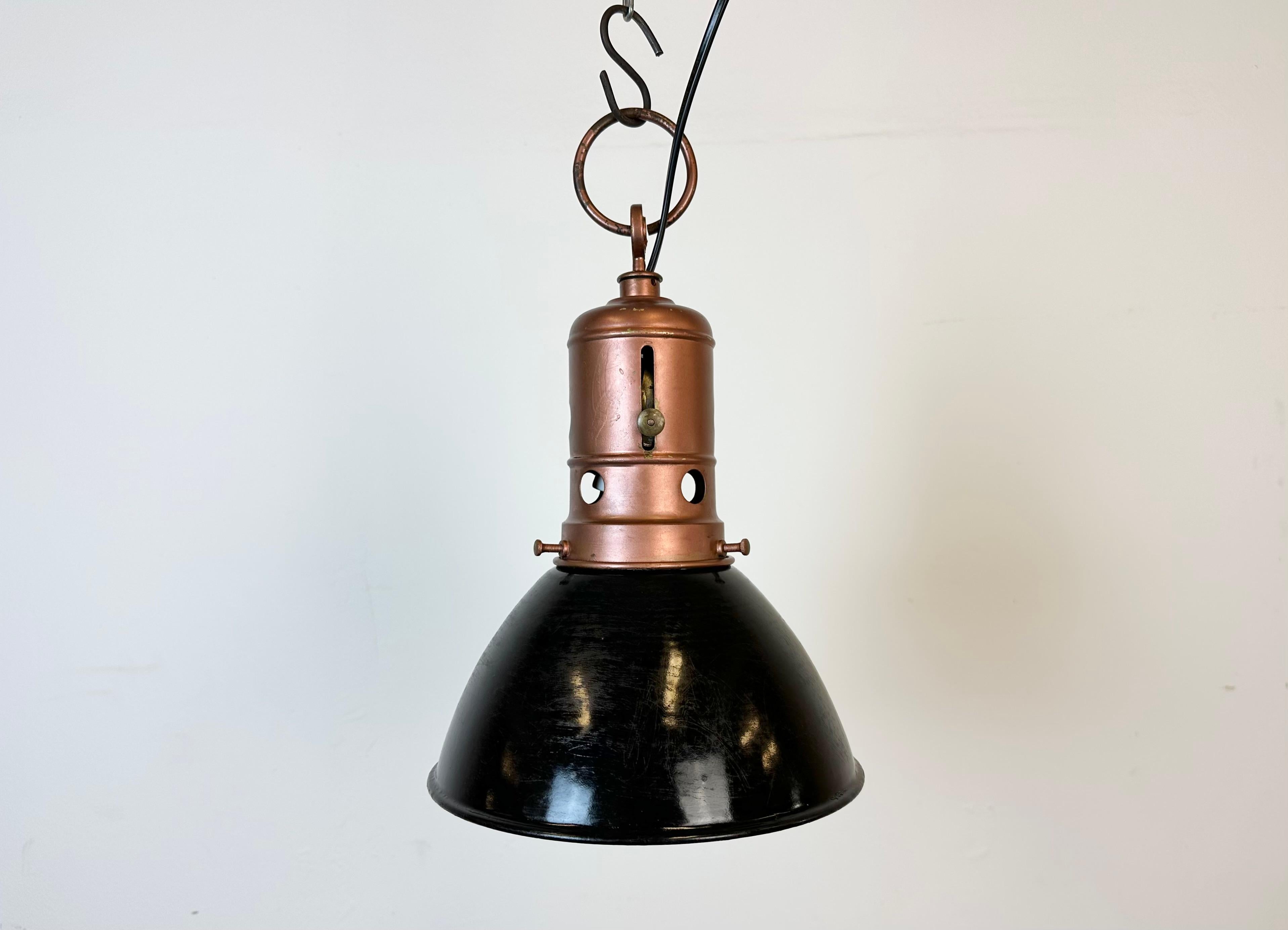 Industrial black enamel factory pendant light made in Italy during the 1950s. White enamel inside the shade. Iron top in copper color. The porcelain socket requires standard E 27/ E26 light bulbs. New wire. The weight of the lamp is 0,9 kg.The