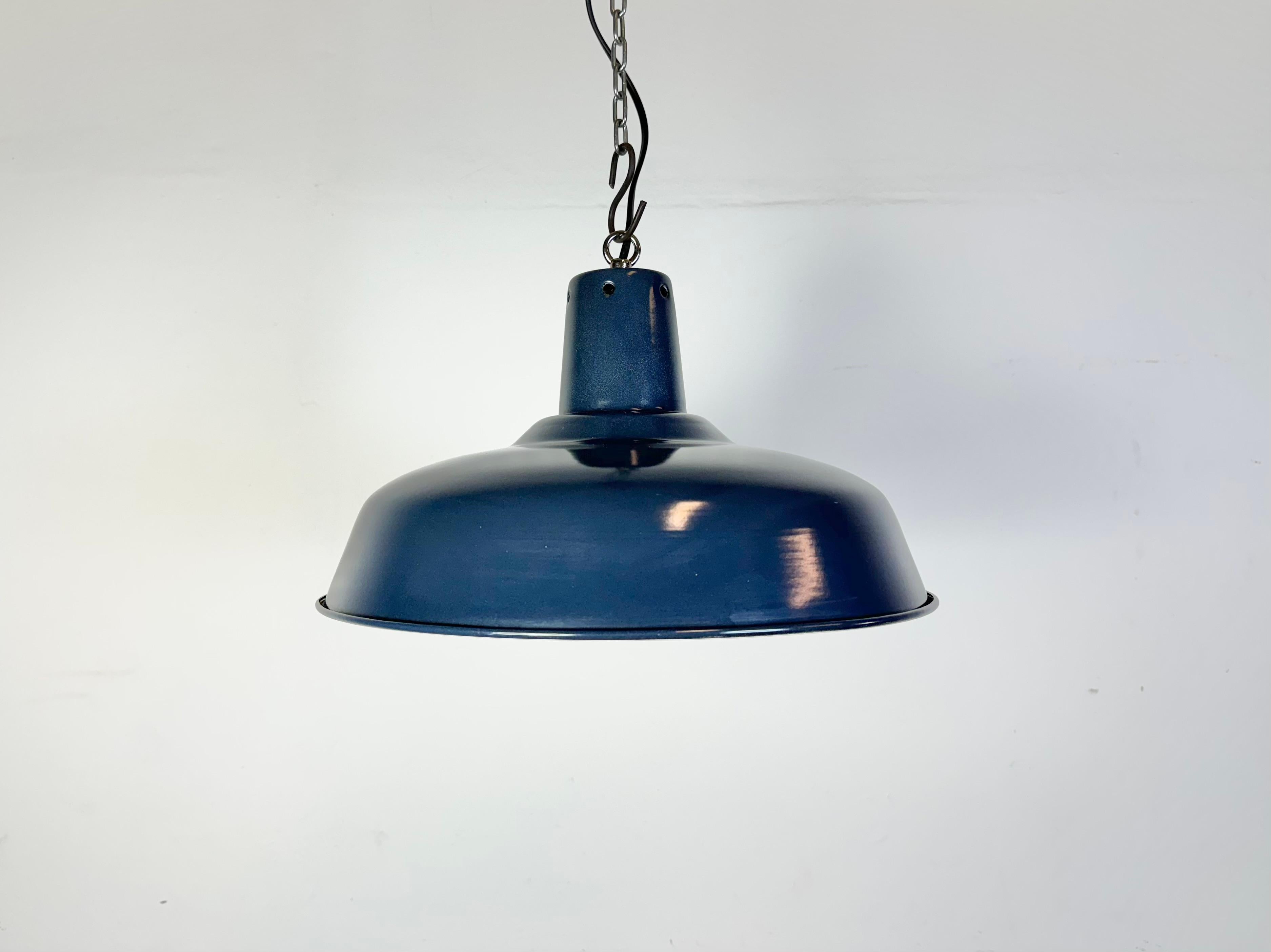Suspension industrielle en émail bleu fabriquée en Italie dans les années 1960. Émail blanc à l'intérieur de la teinte. Dessus en fer. La douille est compatible avec les ampoules standard E 27/ E 26. Un nouveau fil. Le poids de la lampe est de 1 kg.