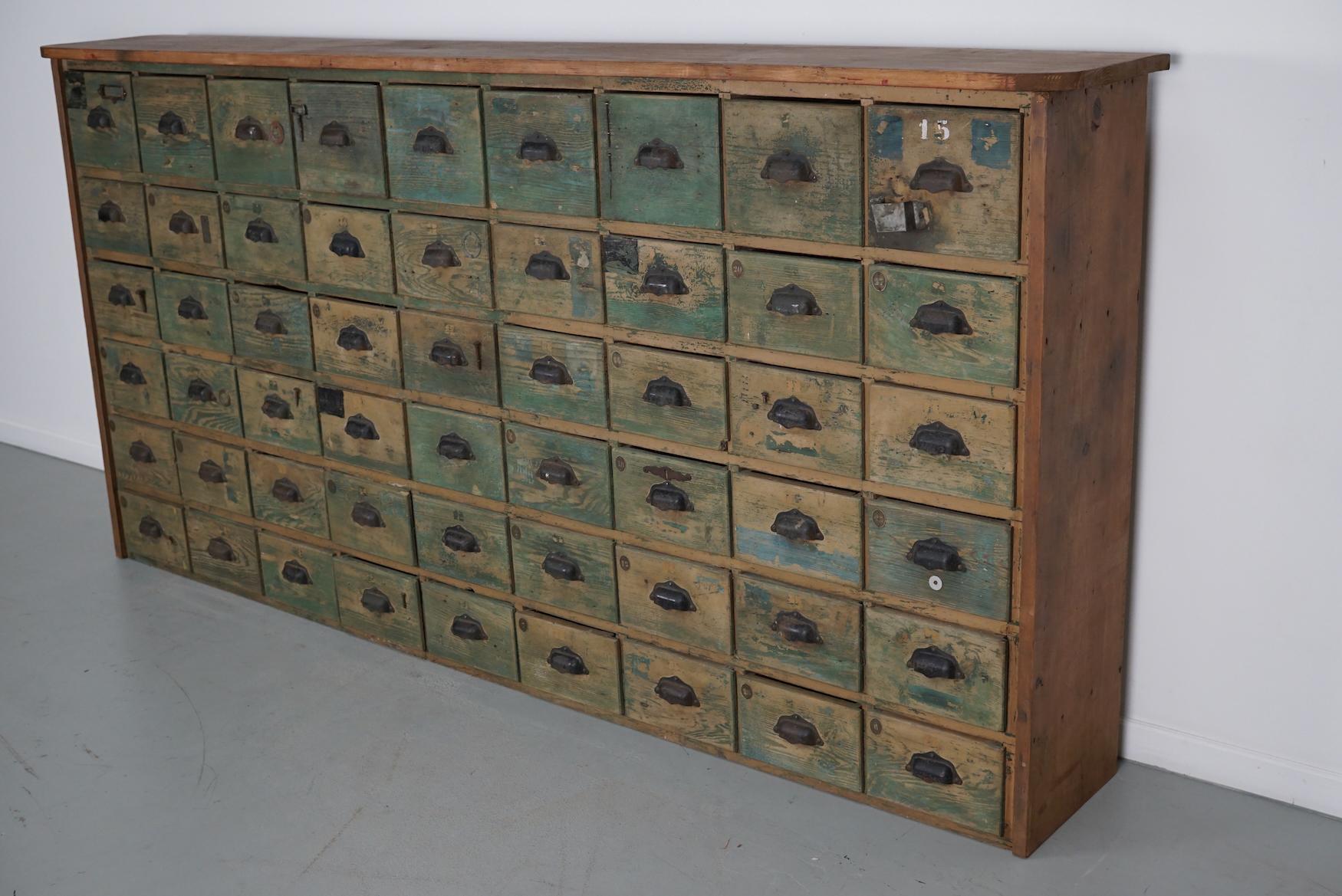 Dieser große Baumarktschrank wurde in den 1950er Jahren in Frankreich aus Kiefernholz hergestellt. Er verfügt über 54 Schubladen mit den originalen Griffen, Messingnummernschildern und dem Inhalt der Schubladen. Die Innenmaße der Schubladen sind: