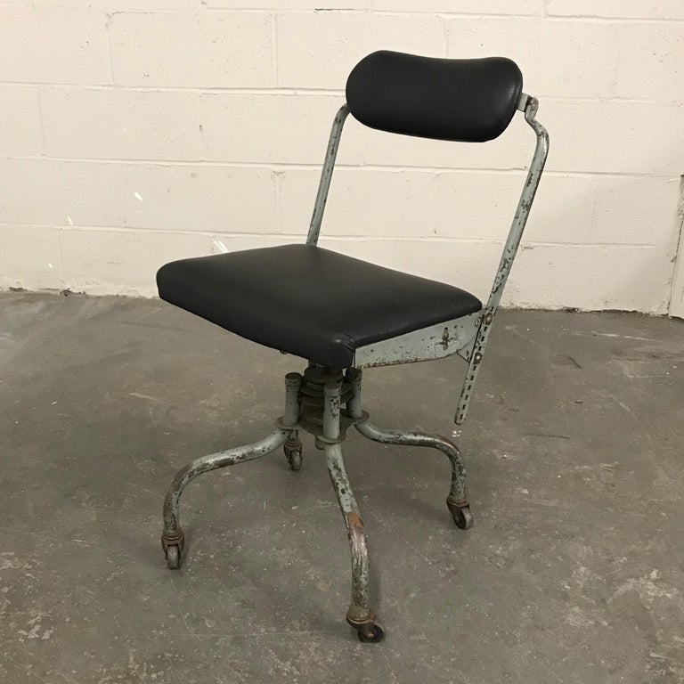 Early 20th century, rolling, swivel, desk chair by Fritz Cross features a painted steel frame in it's original patina contrasted by a newly upholstered seat and back in black leather. Seat is 16 inches w x 12 inches d. The back height and tilt can