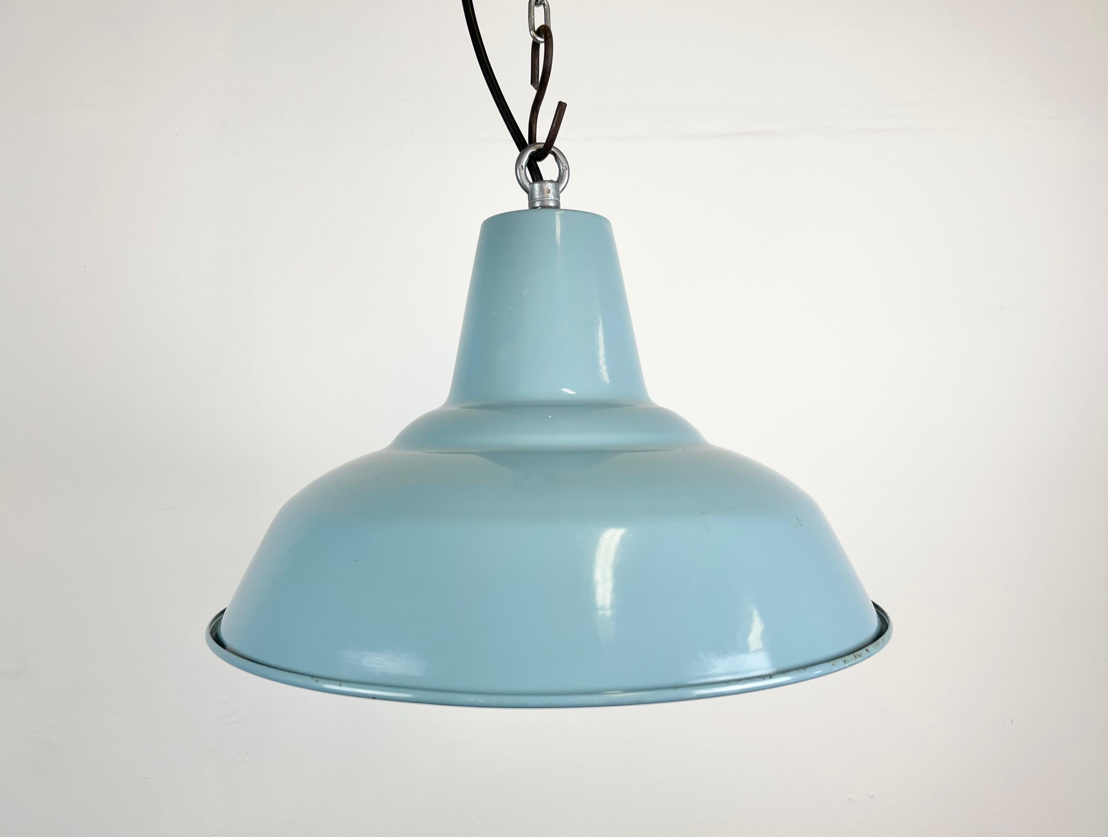 Vintage industrial lamp made during the 1960s. It features a light blue enamel shade with white enamel interior and iron top. New porcelain socket requires E 27 light bulbs. New wire. The weight of the lamp is 0,6 kg.