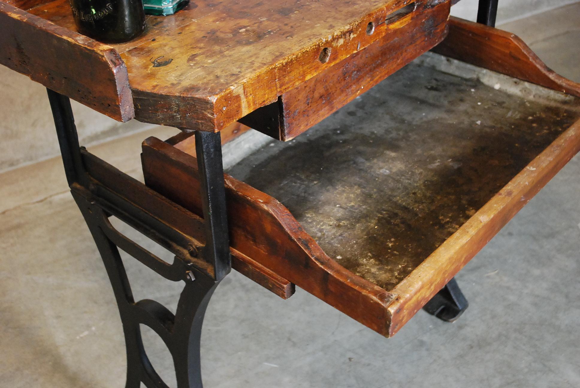 Vintage, 1930s, Industrial, jeweler's bench or table features a beautifully rustic, work worn maple top stained to a walnut finish with two pull-out drawers in a cast iron frame.
Excellent as found condition.