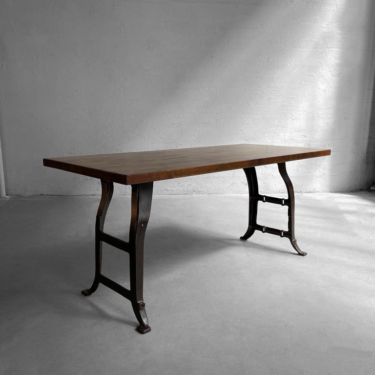 Custom, industrial table features a 1.5 inch thick, reclaimed, stained maple block top with fastener detail and antique cast iron, machine legs. The table has multiple uses - work table, desk, dining table or console. A cFsignature piece made in