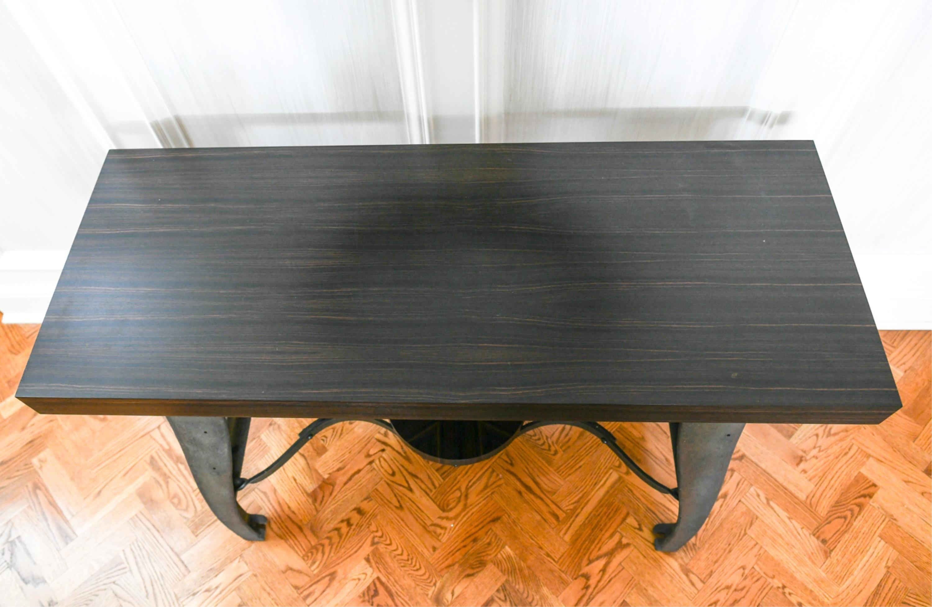 Dieser Tisch ist mit seiner Platte aus exotischem Holz und dem maßgefertigten Gestell in der Mitte des Sockels eine coole und moderne Ergänzung für Ihren Raum. Mit Ebenholz-Makassar-Holz, das von einem Meister auf diesem Gebiet gebaut wurde. Der