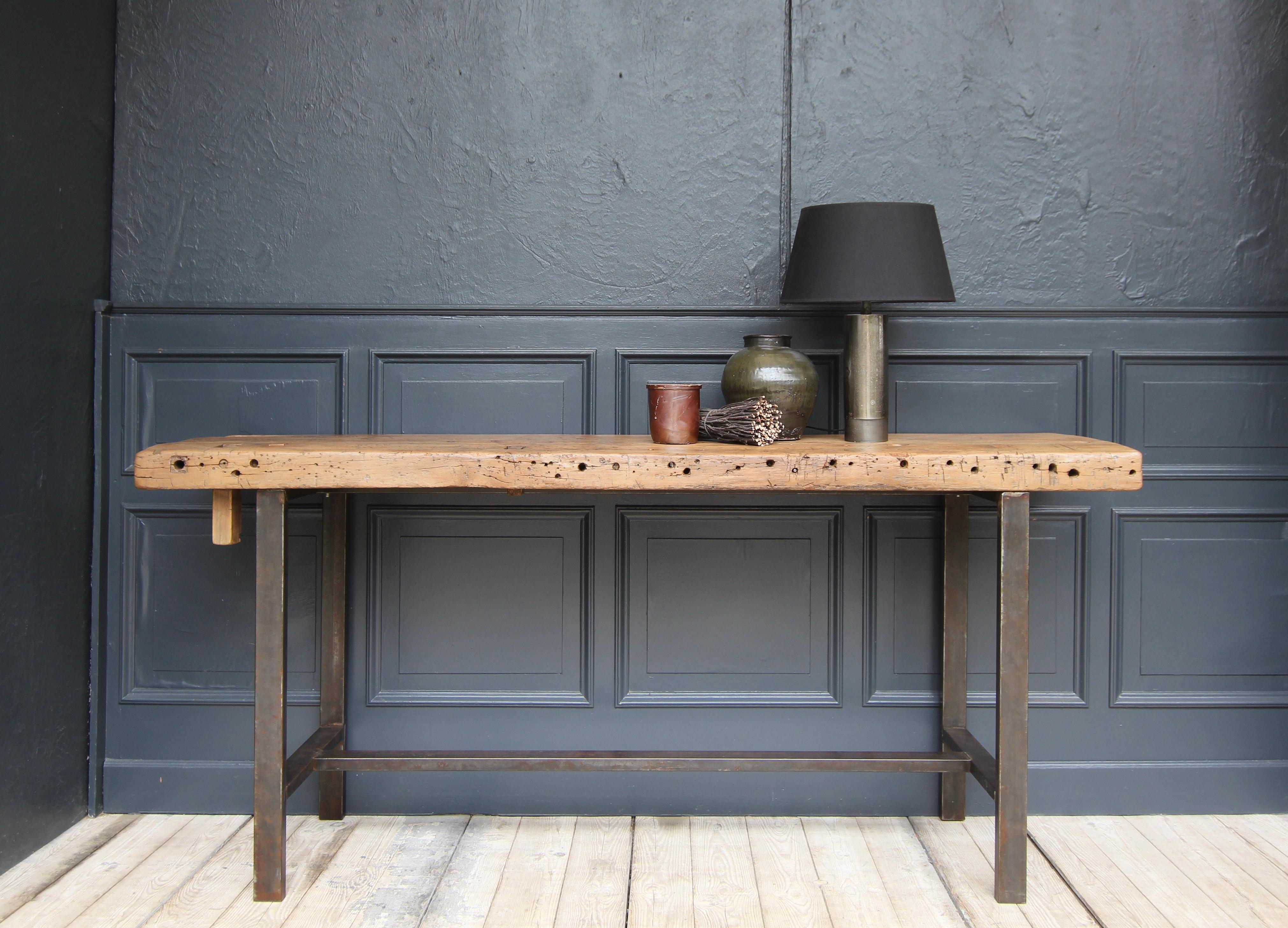 A former industrial work table with metal frame. 

Very stylish, unique piece that is characterised by its purist design and the combination of a modern-looking metal frame and the patina of an old workbench top from the early 20th century. Ideal as