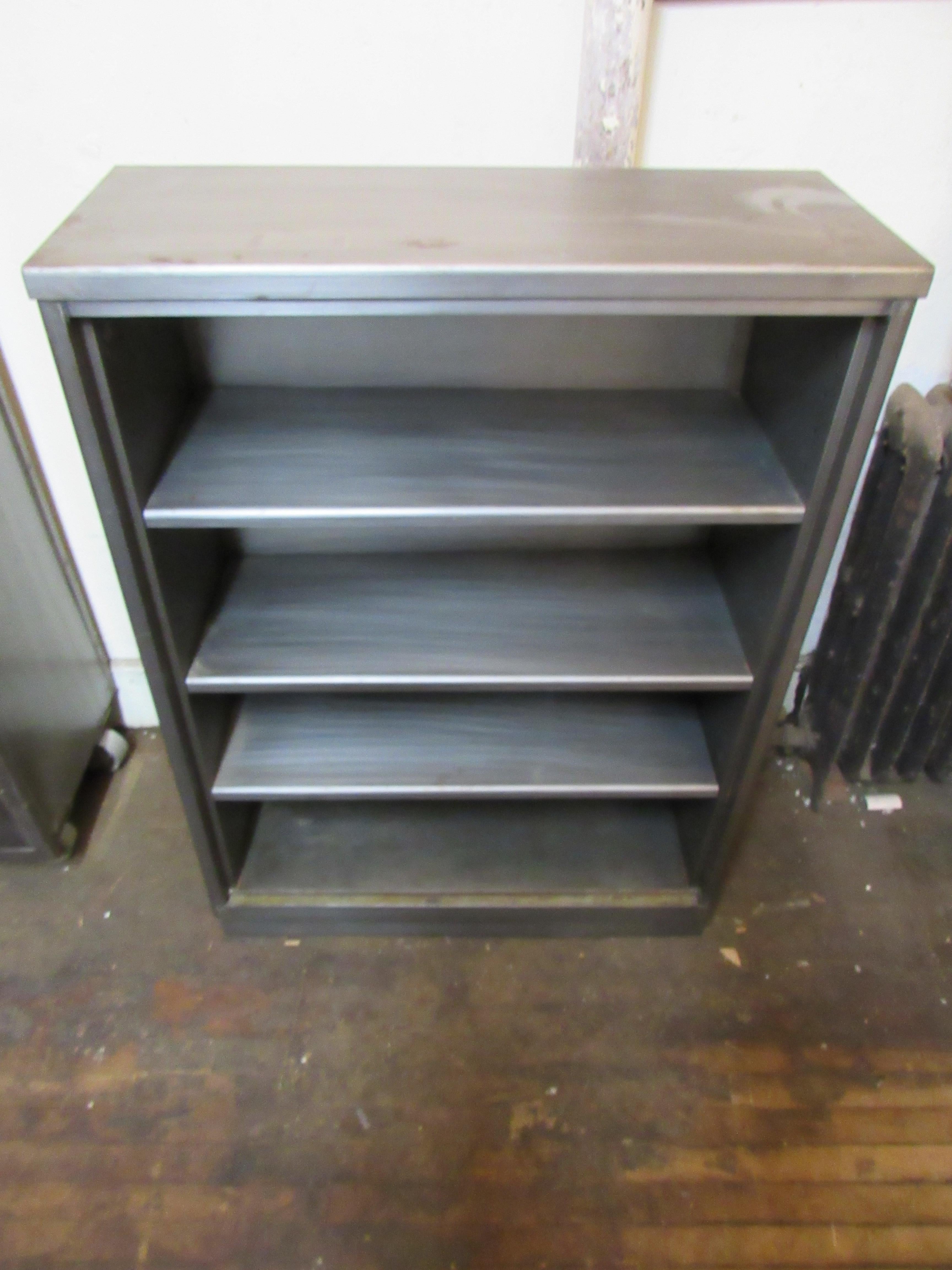 Four foot high metal bookcase with three adjustable shelves. This piece has been taken down to bare metal and then sealed, giving a handsome industrial finish.
Please confirm location NY or NJ