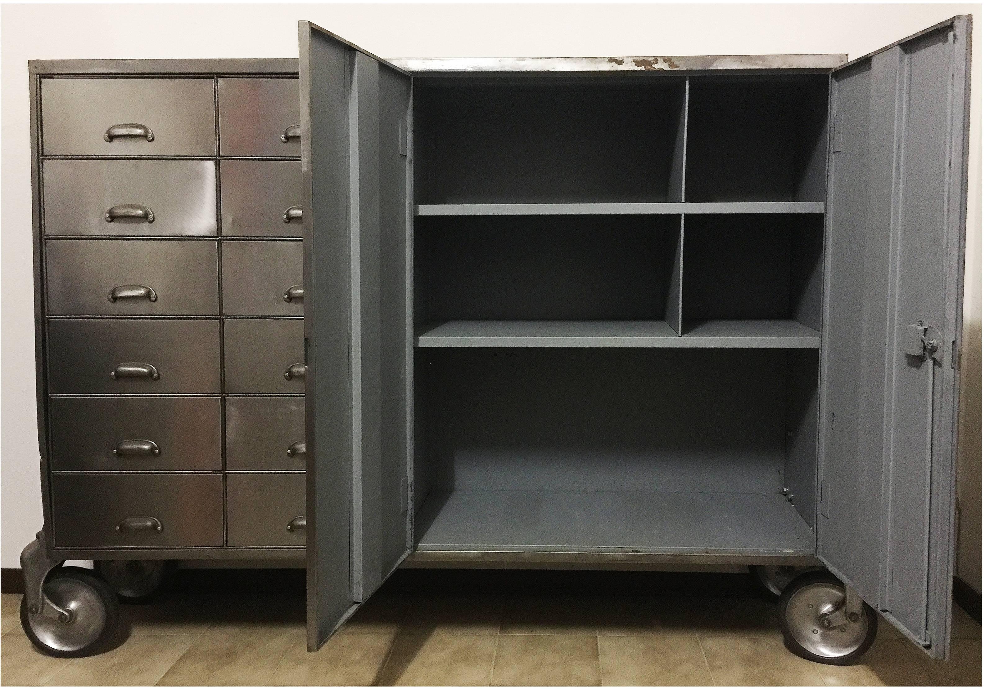 Industrial metal cabinet with unique details such as rounded cast aluminium caster brackets and pull handles.
12 storage drawers and double doors with internal shelf and dividers.
The cabinet was purchased from Castle Gibson in the U.K. in 1999.