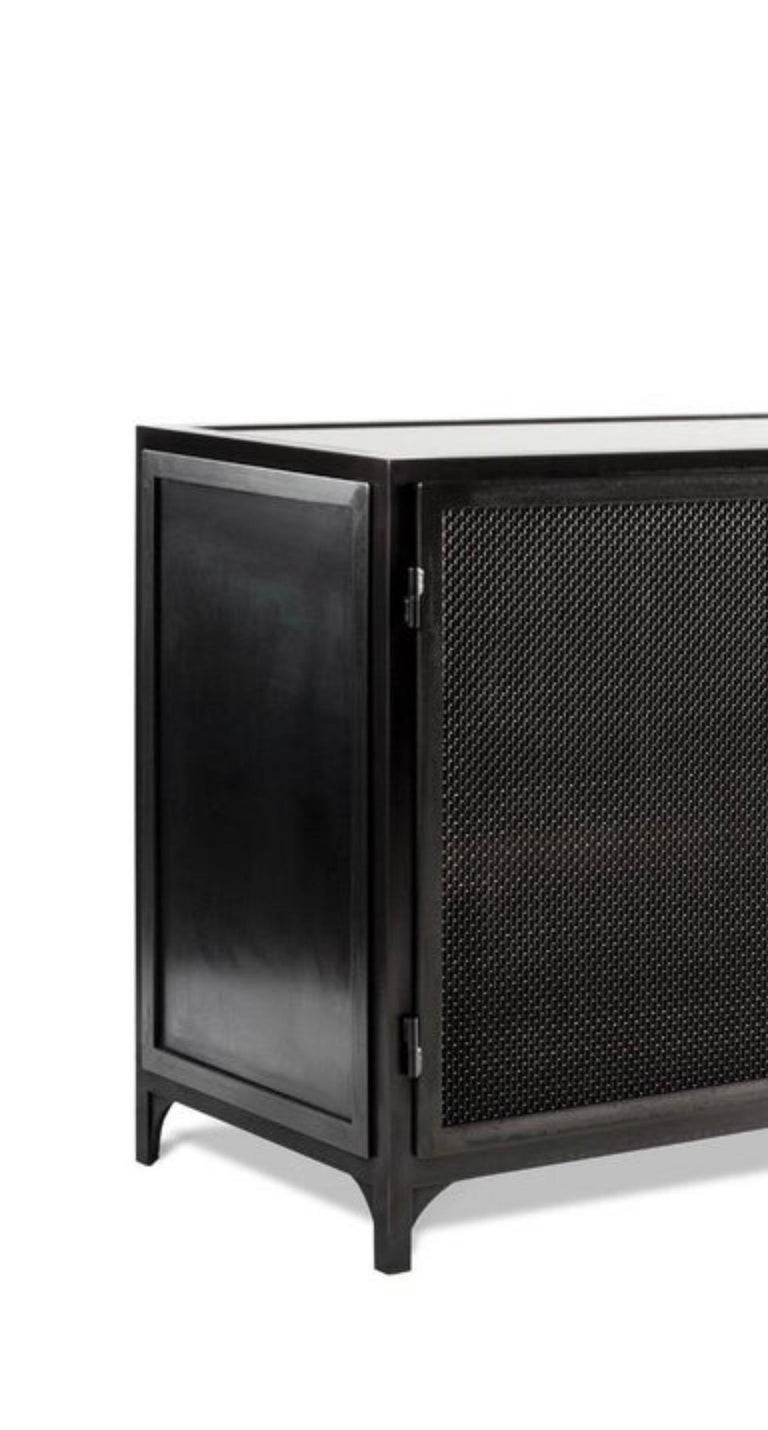 The Bailey console is a durable and stately storage piece. Its Classic metal working details, mesh screen double doors, and sleek blackened finish makes this solid unit a great storage piece for any living space. 

This piece is built with two