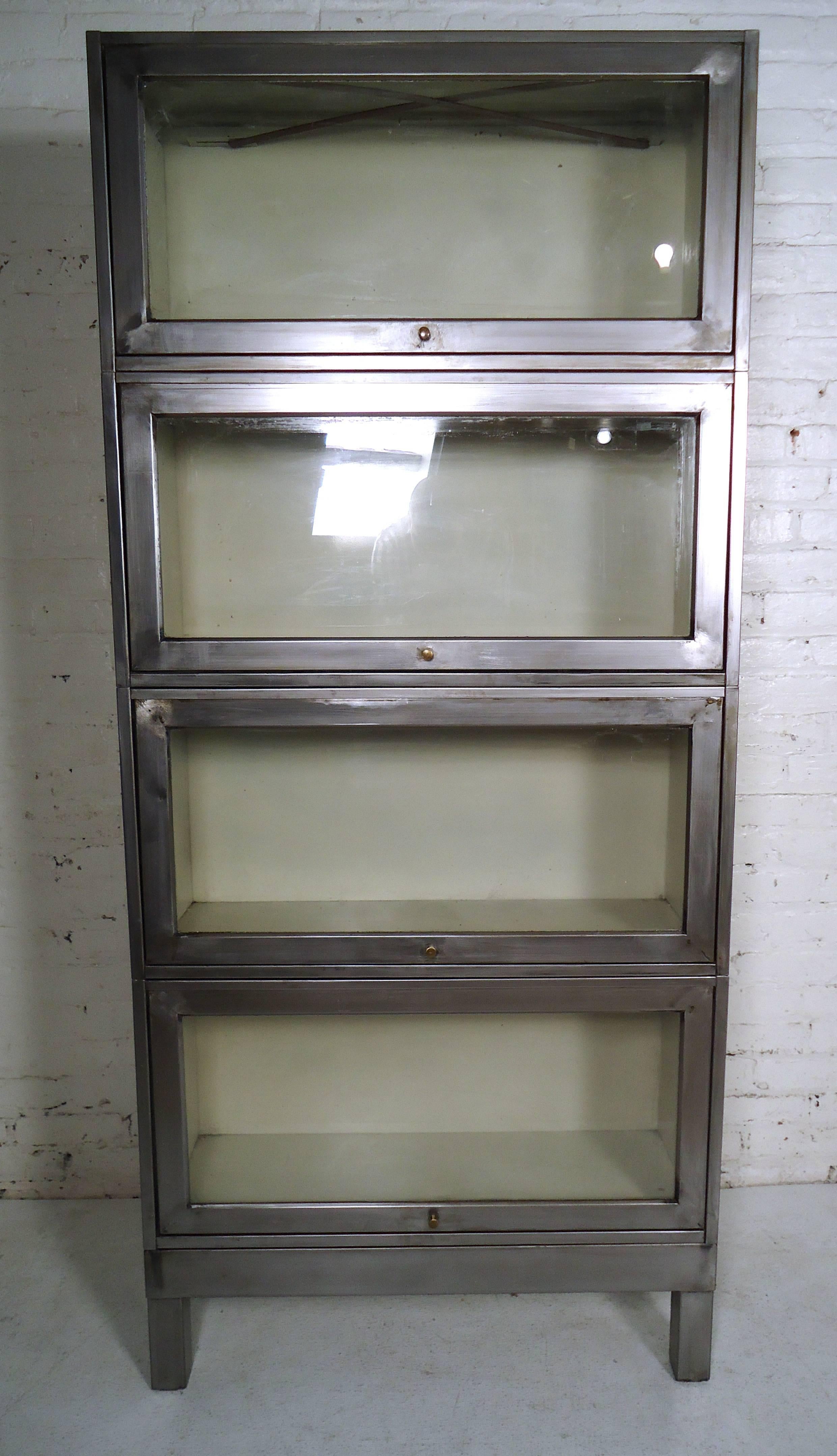 Vintage industrial metal four-stack bookcase features a glass front, round metal knobs and a sturdy metal detachable base.

Please confirm item location (NY or NJ).