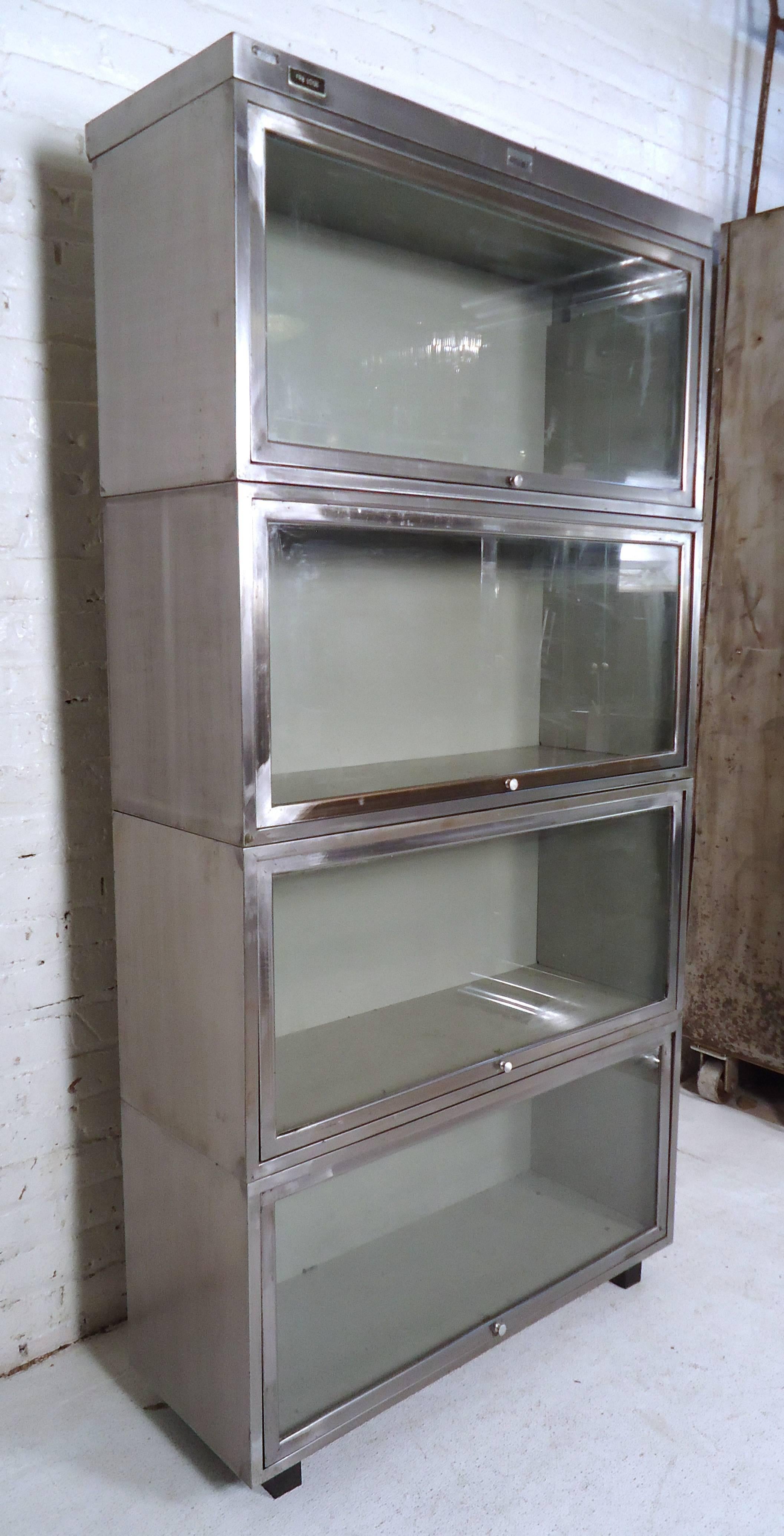 Vintage industrial metal four-stack bookcase features a glass front, round metal knobs and a sturdy metal detachable base.

Please confirm item location (NY or NJ).