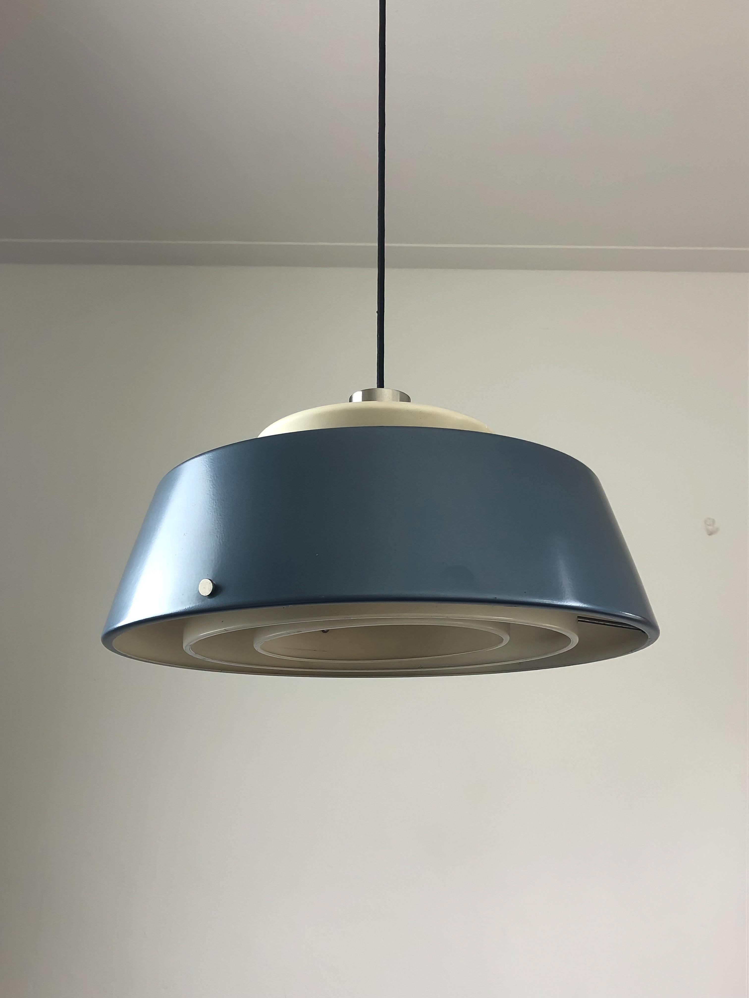 Lampe suspendue fabriquée par le fabricant de luminaires italien Stilnovo au début des années 1960. Le design de cette lampe présente un abat-jour laqué bleu métallique qui renferme de multiples structures blanches à l'intérieur. La lampe diffuse la
