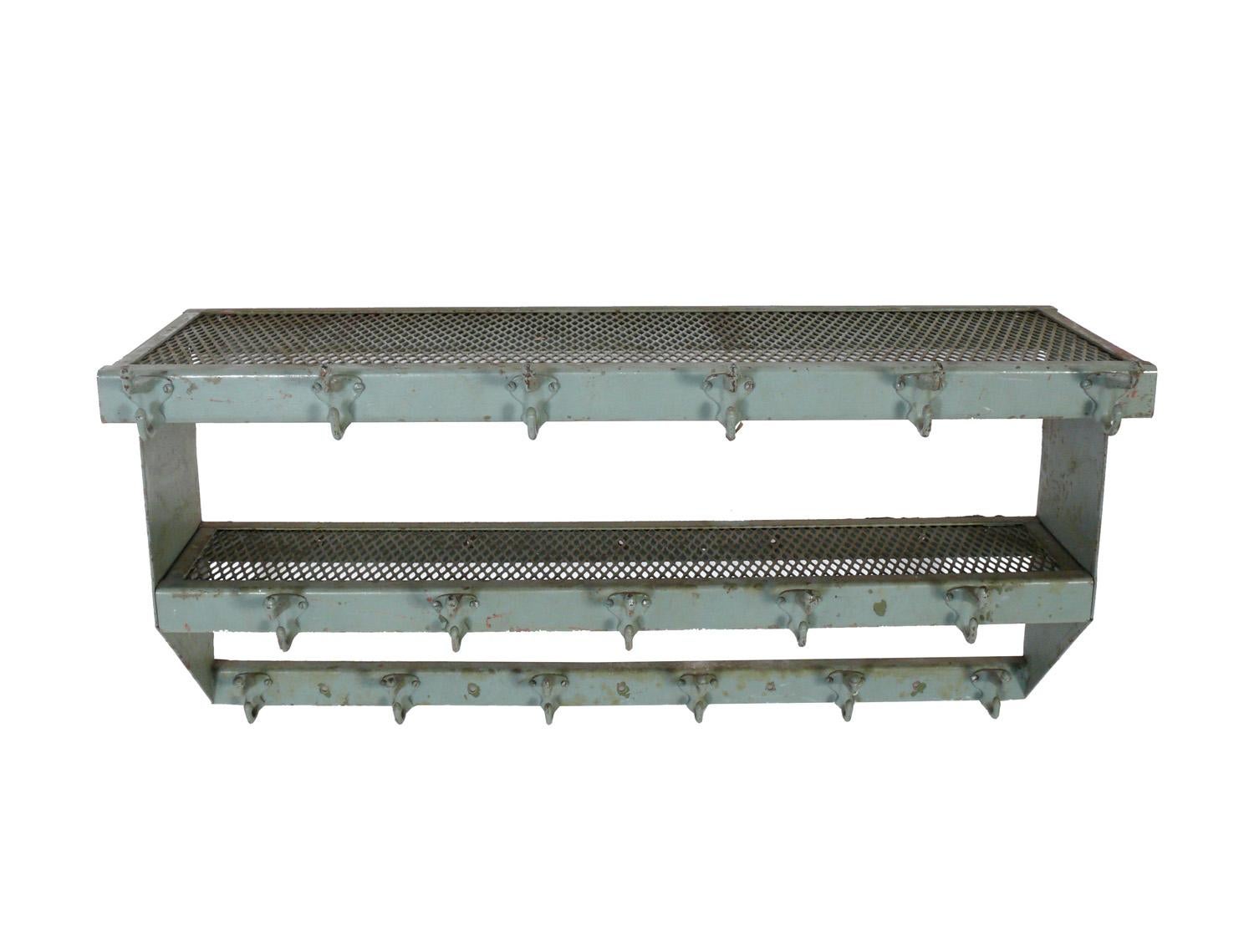 Industrial metal shelves with coat hangers, American, circa 1950s. They retain their original patina, covered in multiple layers of paint and graffiti from over the years. They are a versatile size and can be used in an entry or mud room to hang